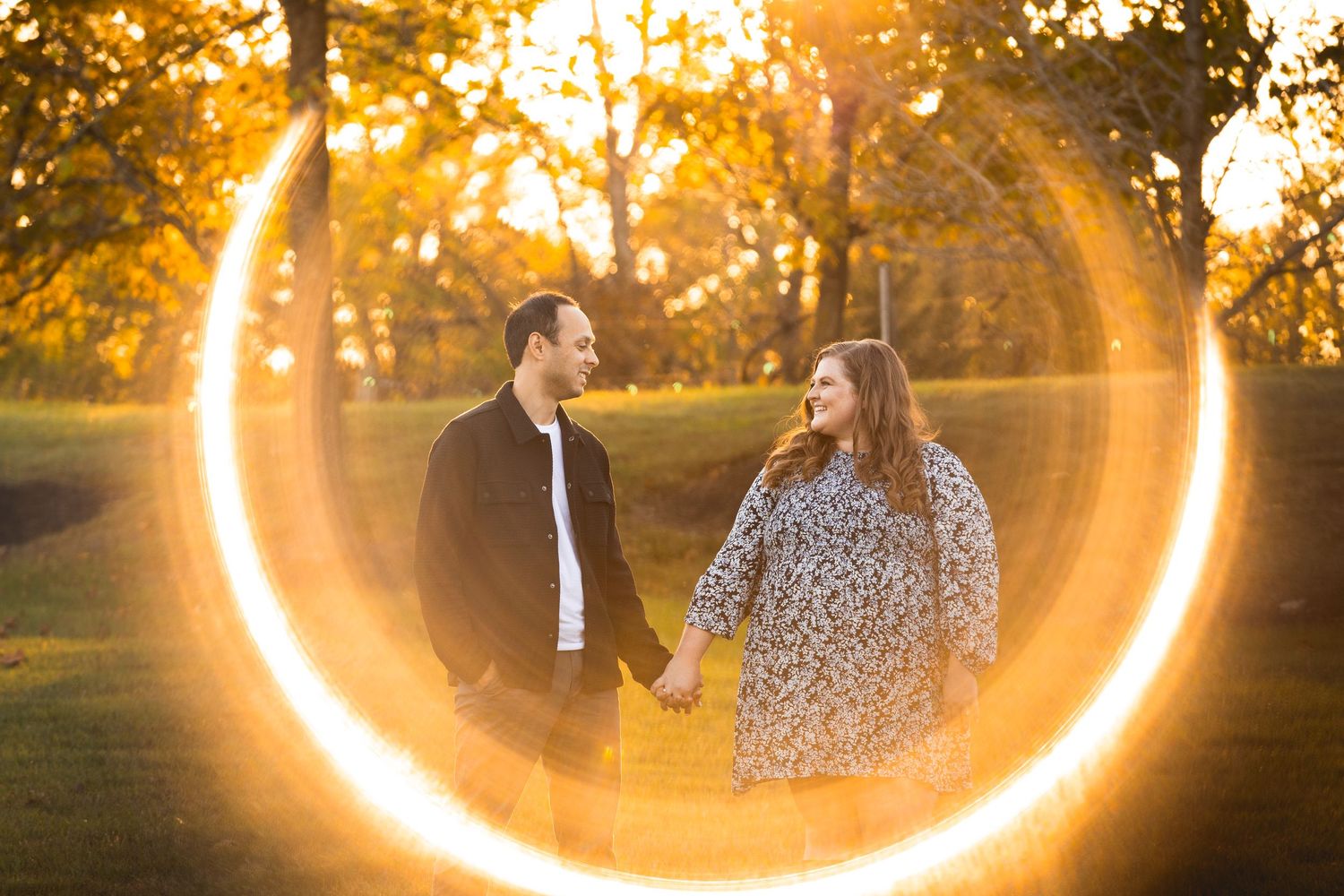 Golden sunlight creates magical ring effect around couple during sunset photoshoot.