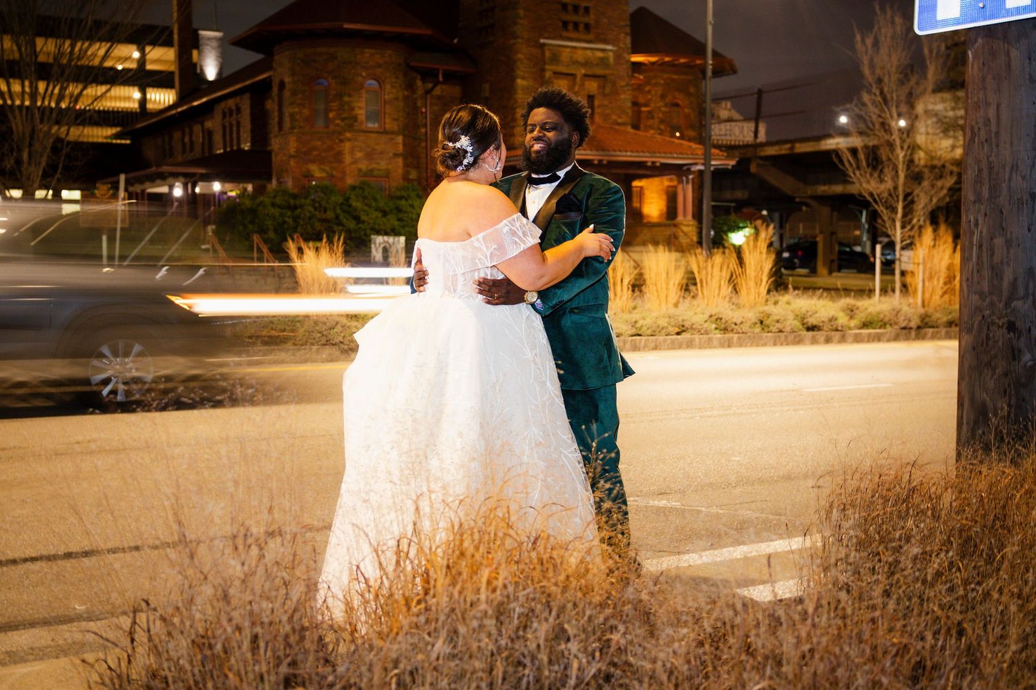 A couple shares an intimate dance moment outdoors among tall grasses at night.