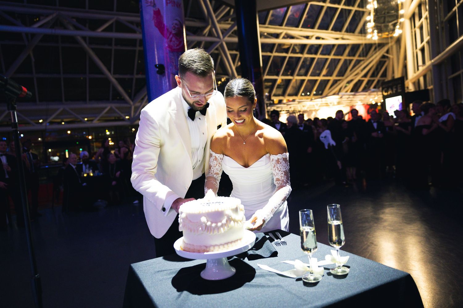 Wedding reception in a dark venue with elegant decor and ambient lighting.