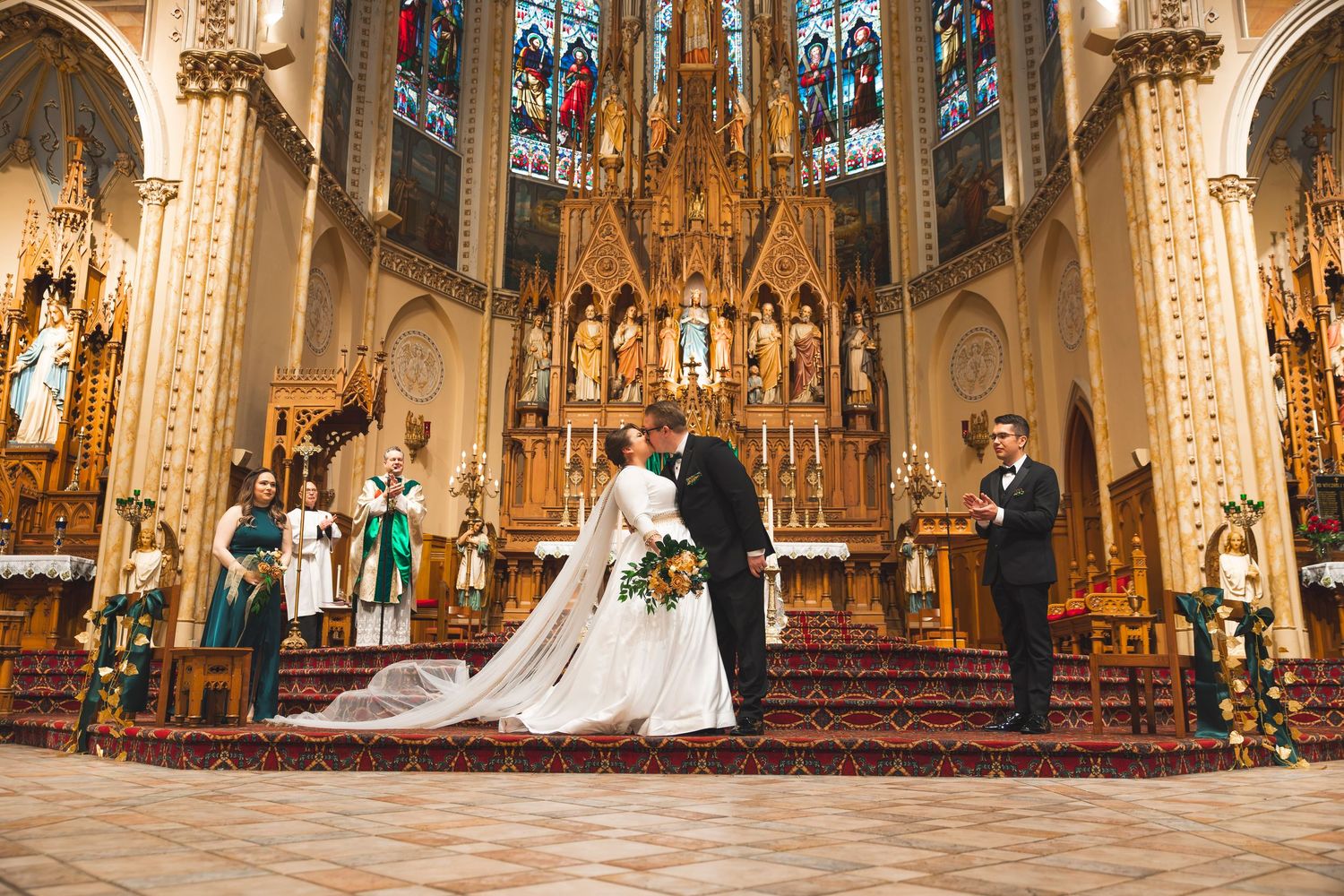 A stunning cathedral wedding ceremony with ornate Gothic architecture and stained glass windows illuminating the grand space.