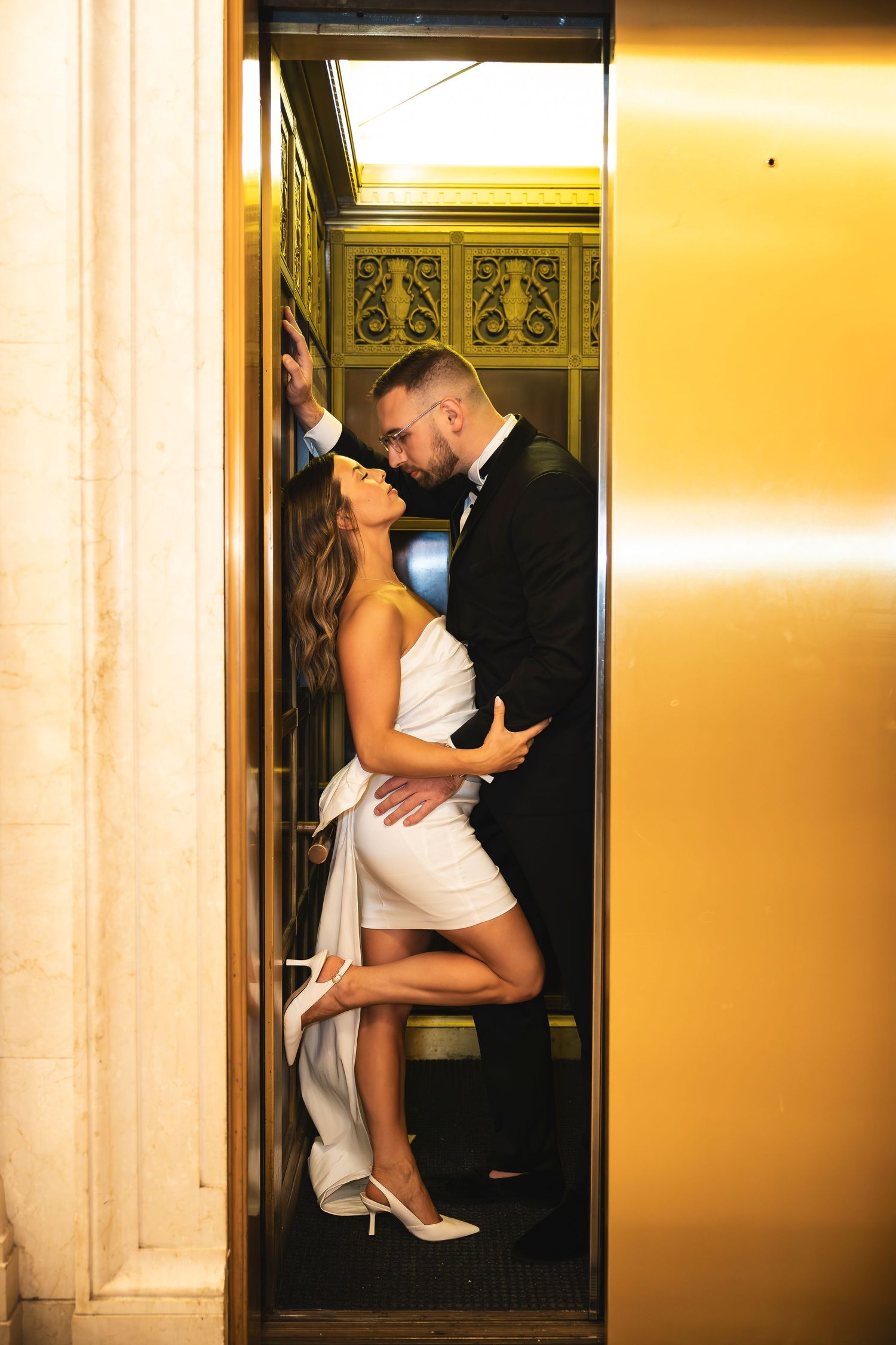 Romantic elevator wedding photos with warm golden lighting.