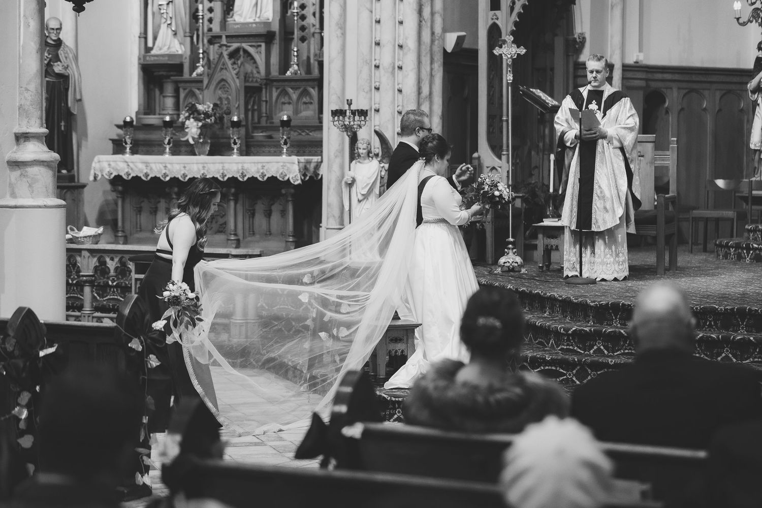 A wedding ceremony unfolds amidst the ornate interior of a classic stone church.