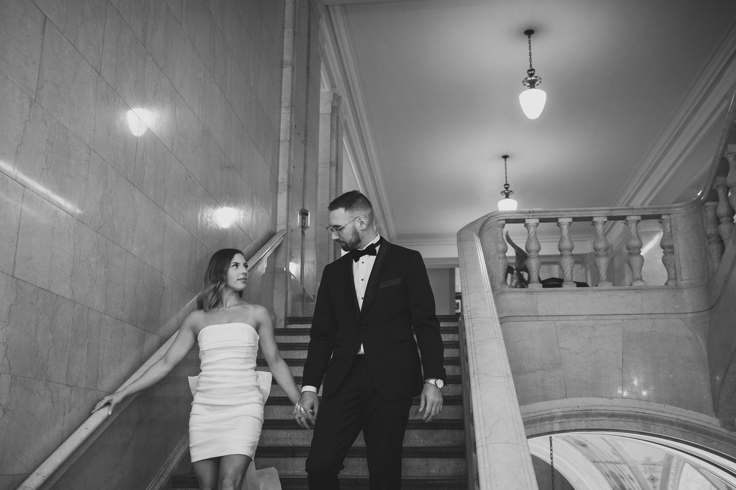 Elegant wedding photography in a minimalist hallway with dramatic lighting.
