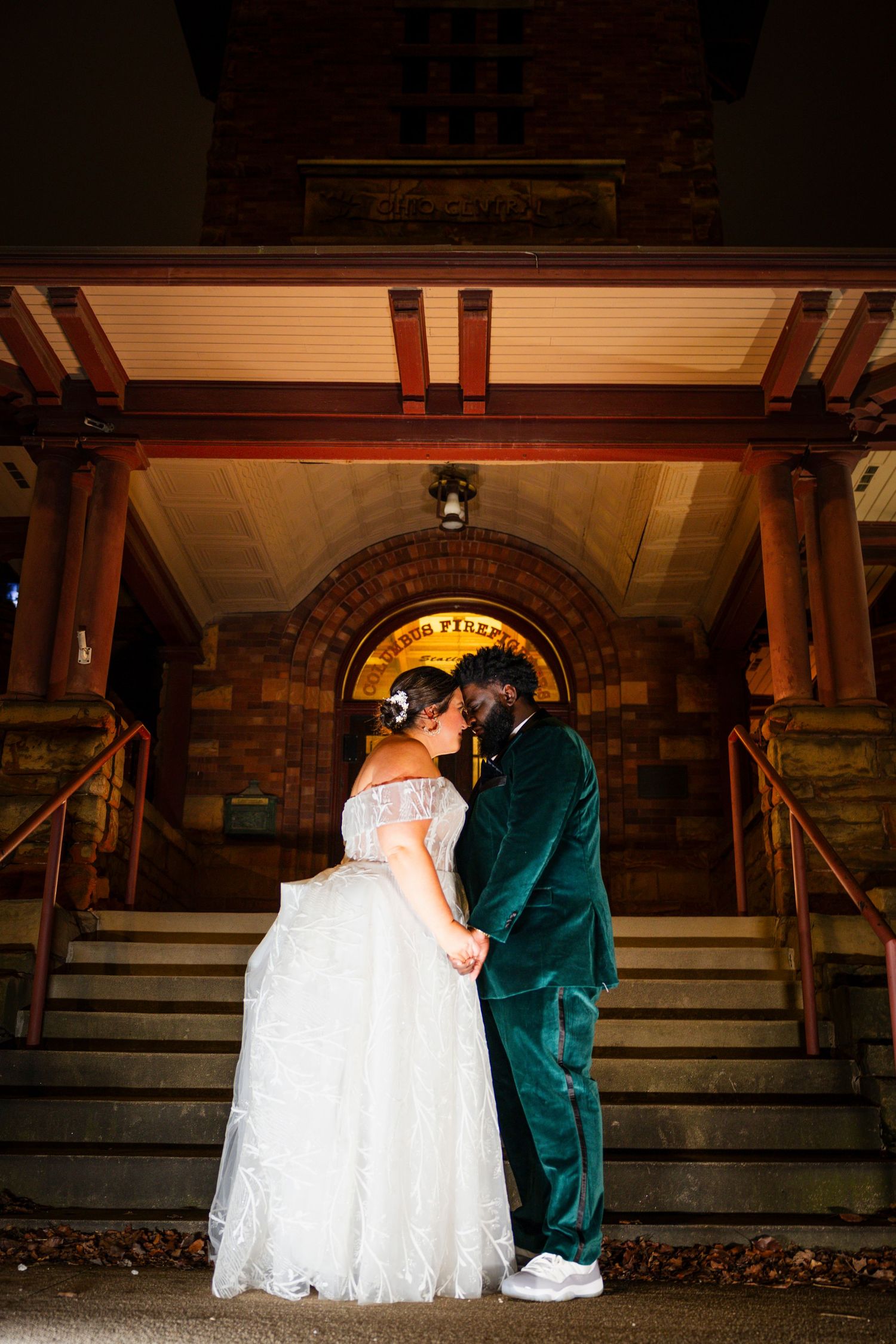 Romantic wedding sequence showing couple in emerald suit and white dress on dimly lit stairs.