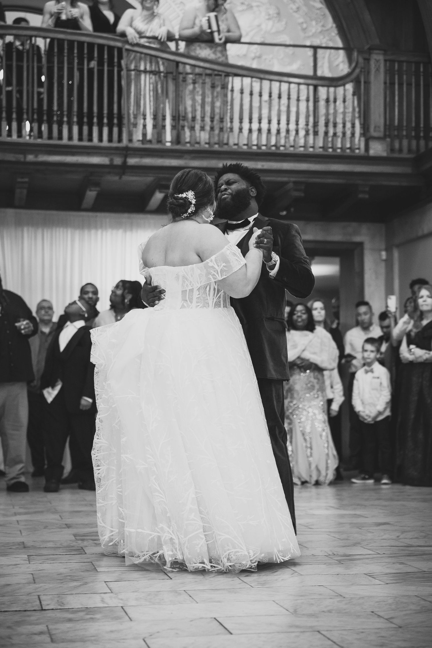 Wedding dance captured in black and white showing a couple's first dance with flowing white dress.