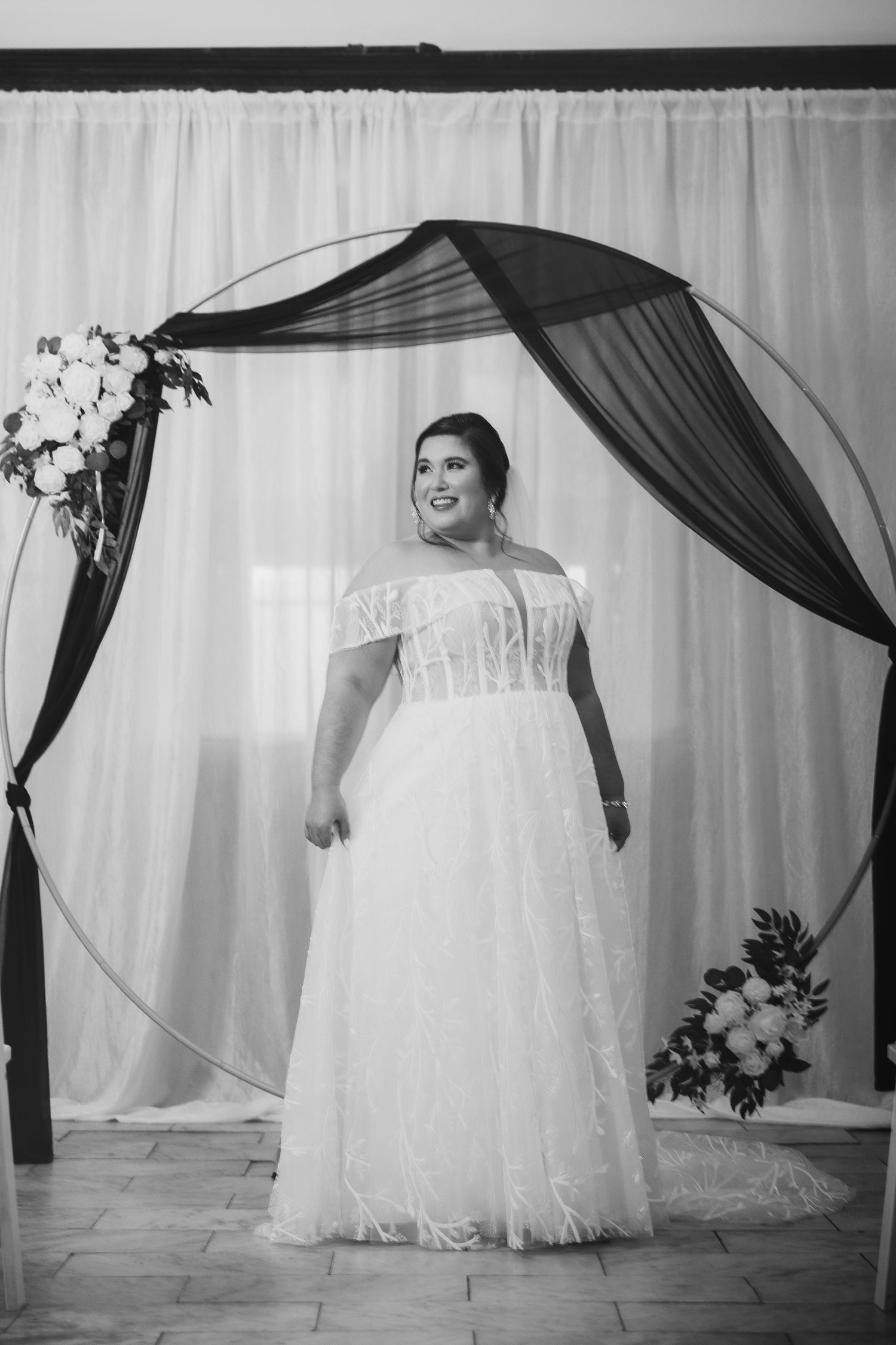 Artistic black and white bridal portraits against white backdrop with elegant draping.