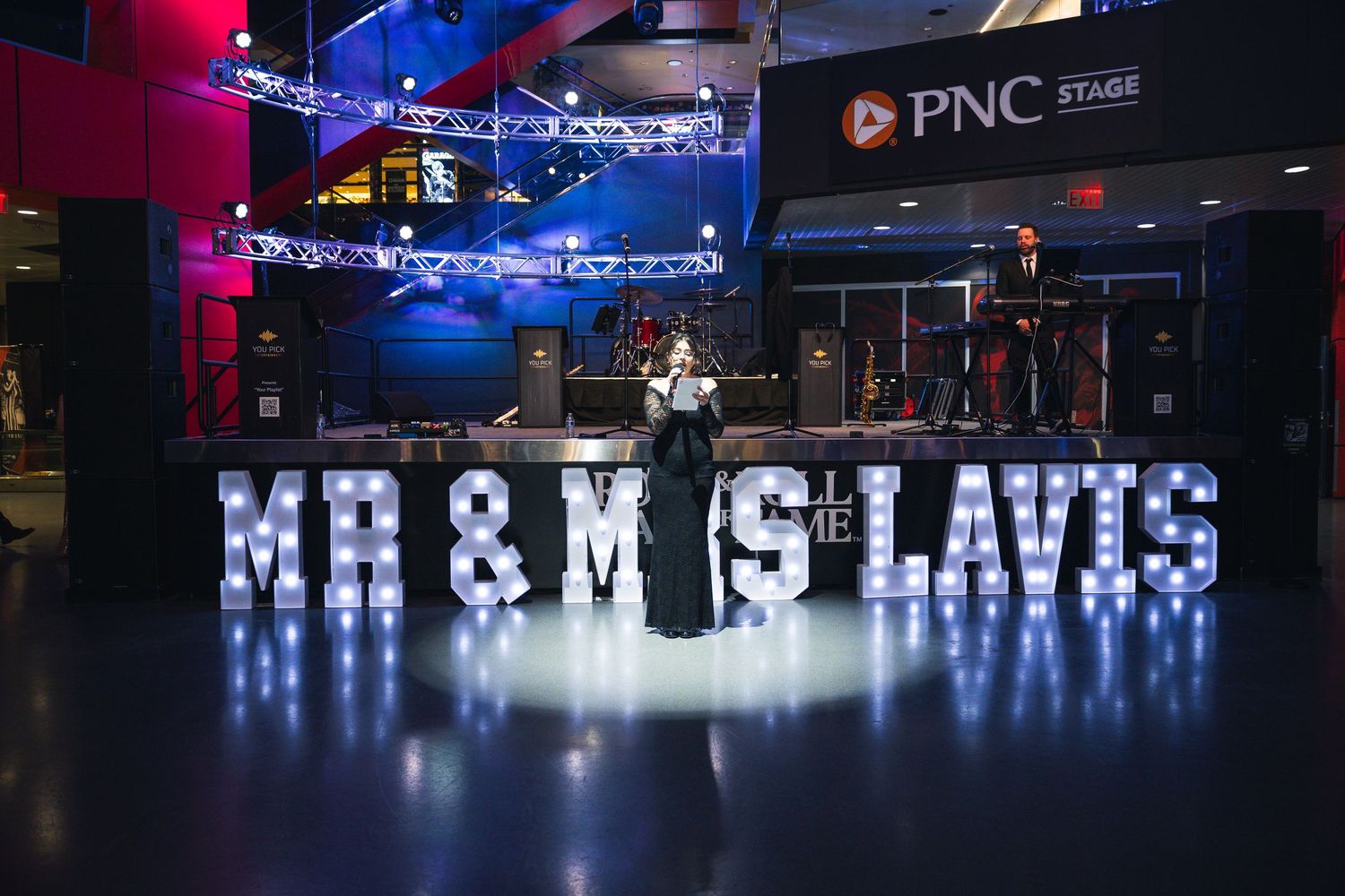 Illuminated marquee letters spell out text against a dark background with blue and red lighting.