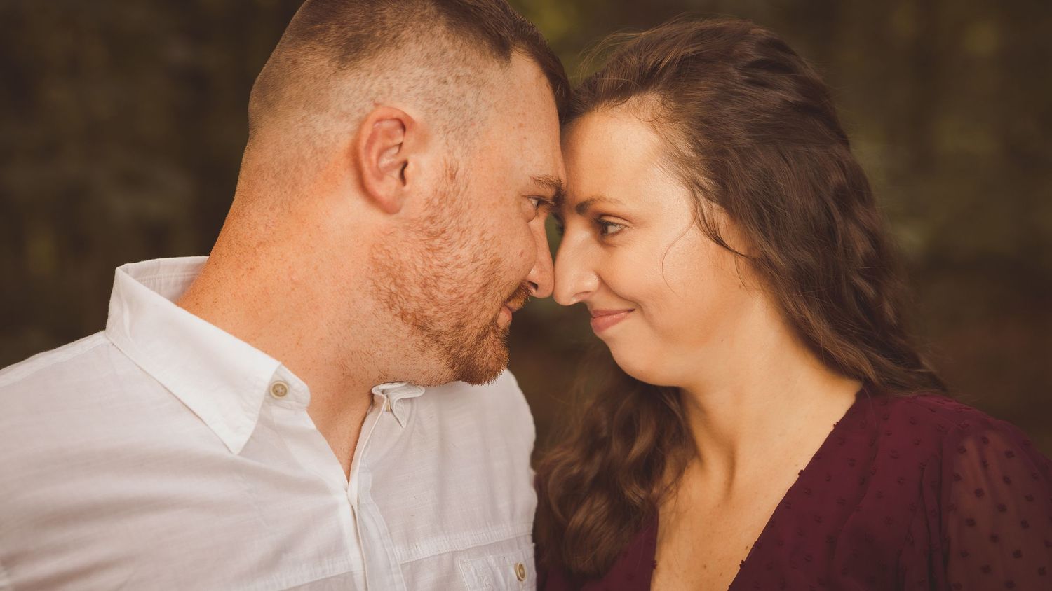Close-up romantic portrait in a garden setting with soft lighting.