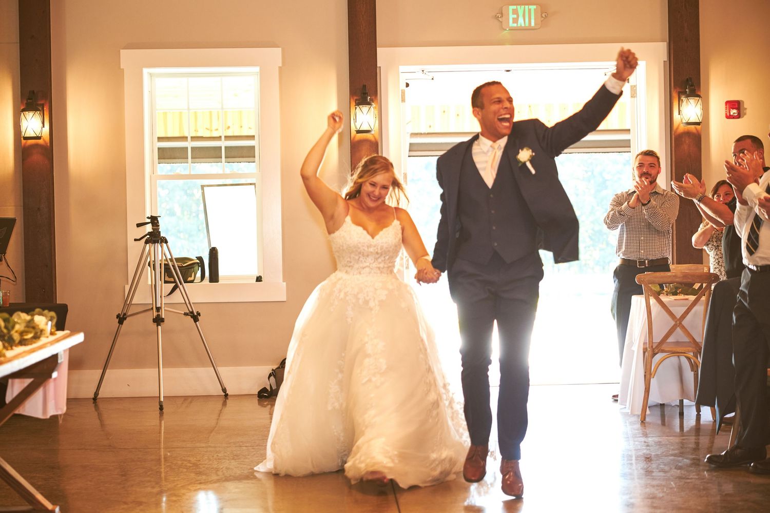 Wedding couple dances and celebrates in an elegant reception hall with guests.