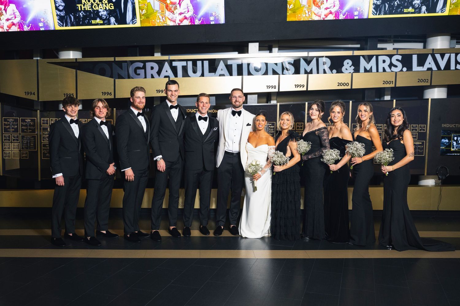 Bride and wedding party members celebrate at an elegant reception venue with a modern design.