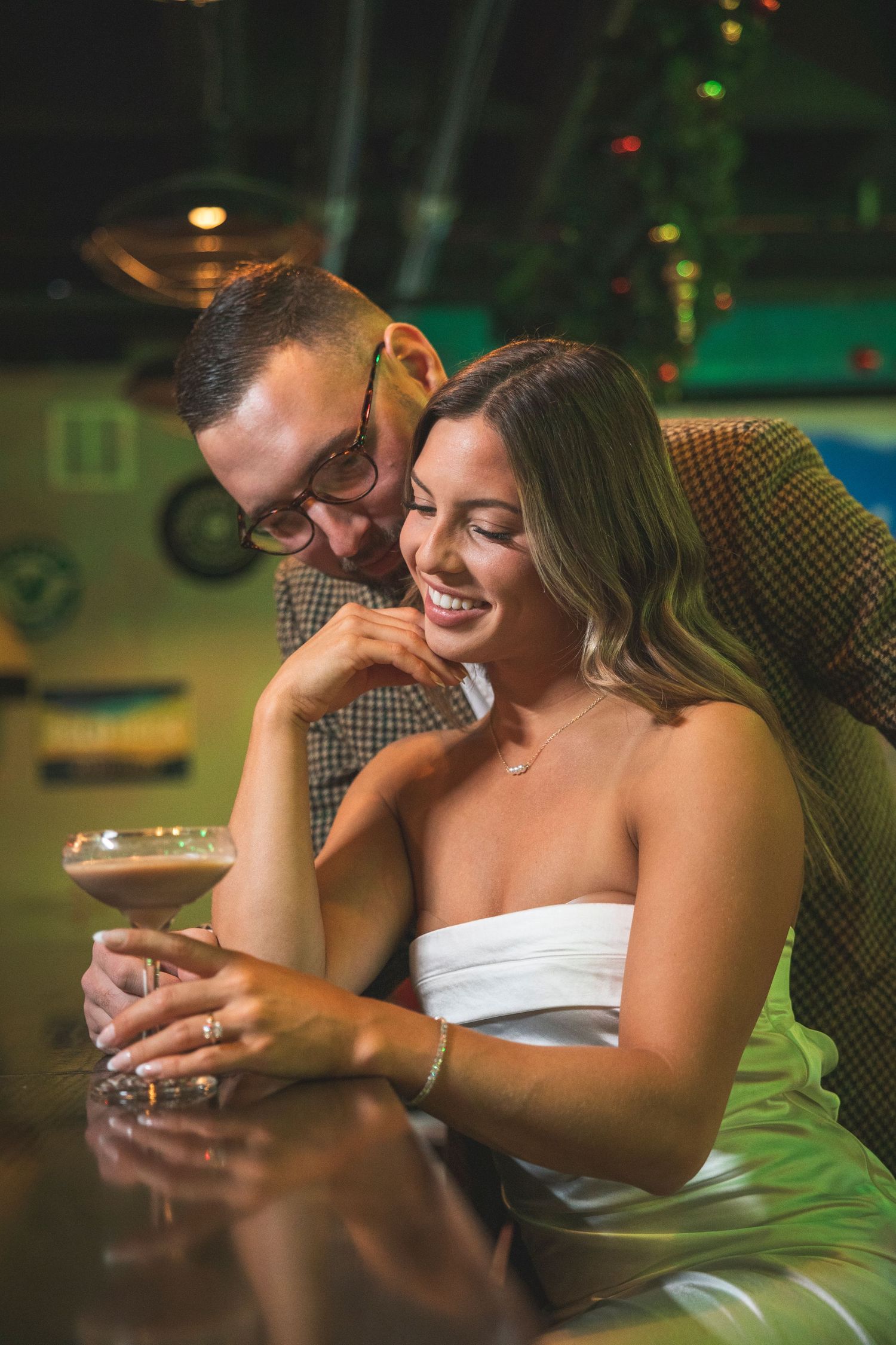 Intimate moment captured at a bar with warm lighting and holiday decorations.