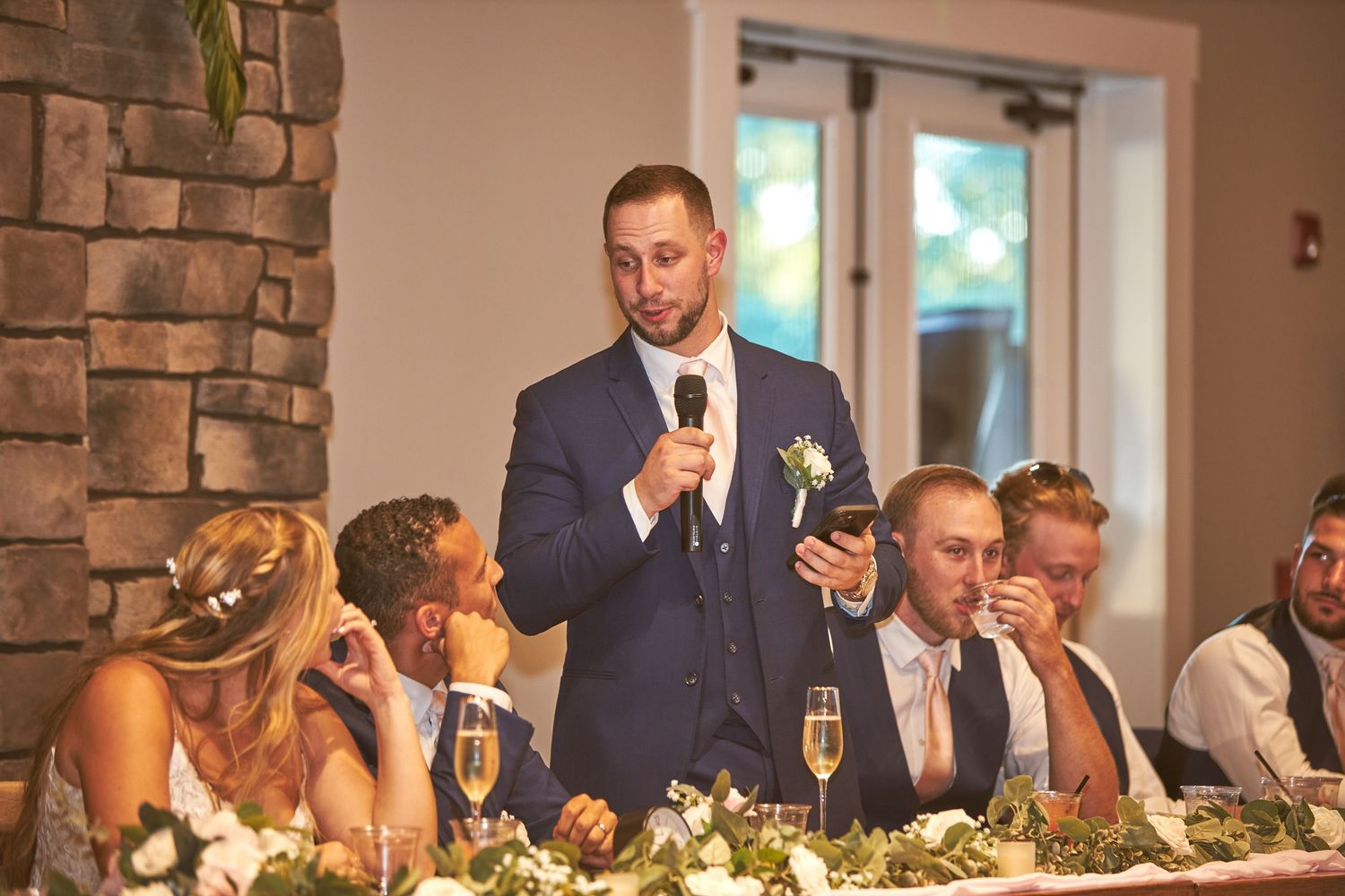 A row of guests enjoy their meals at an elegant wedding reception.