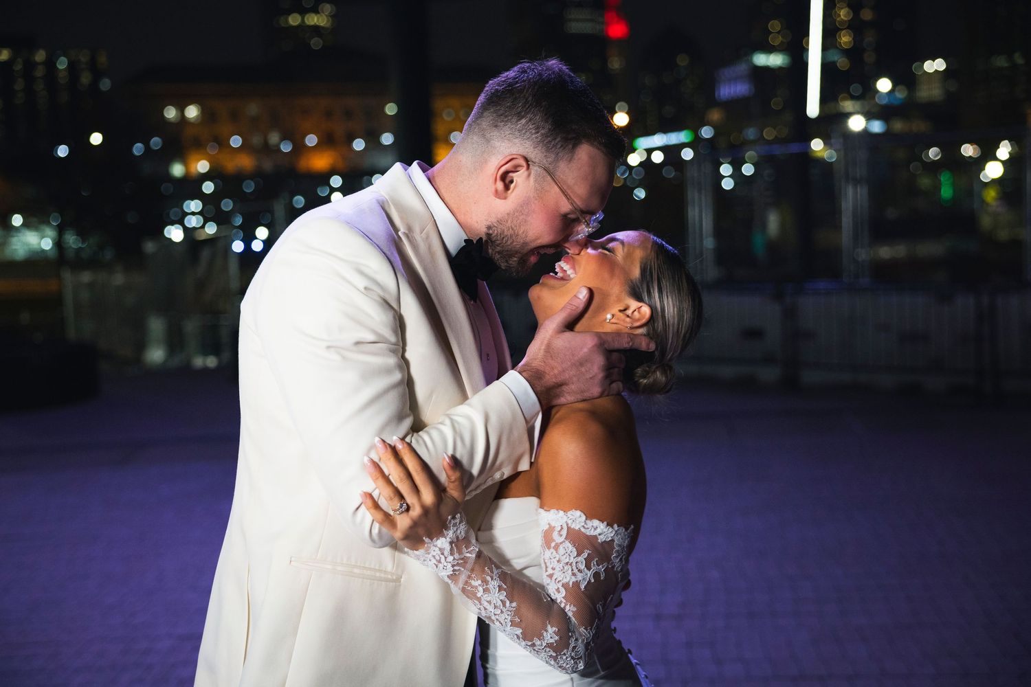 A romantic dance pose silhouetted against city lights at night.