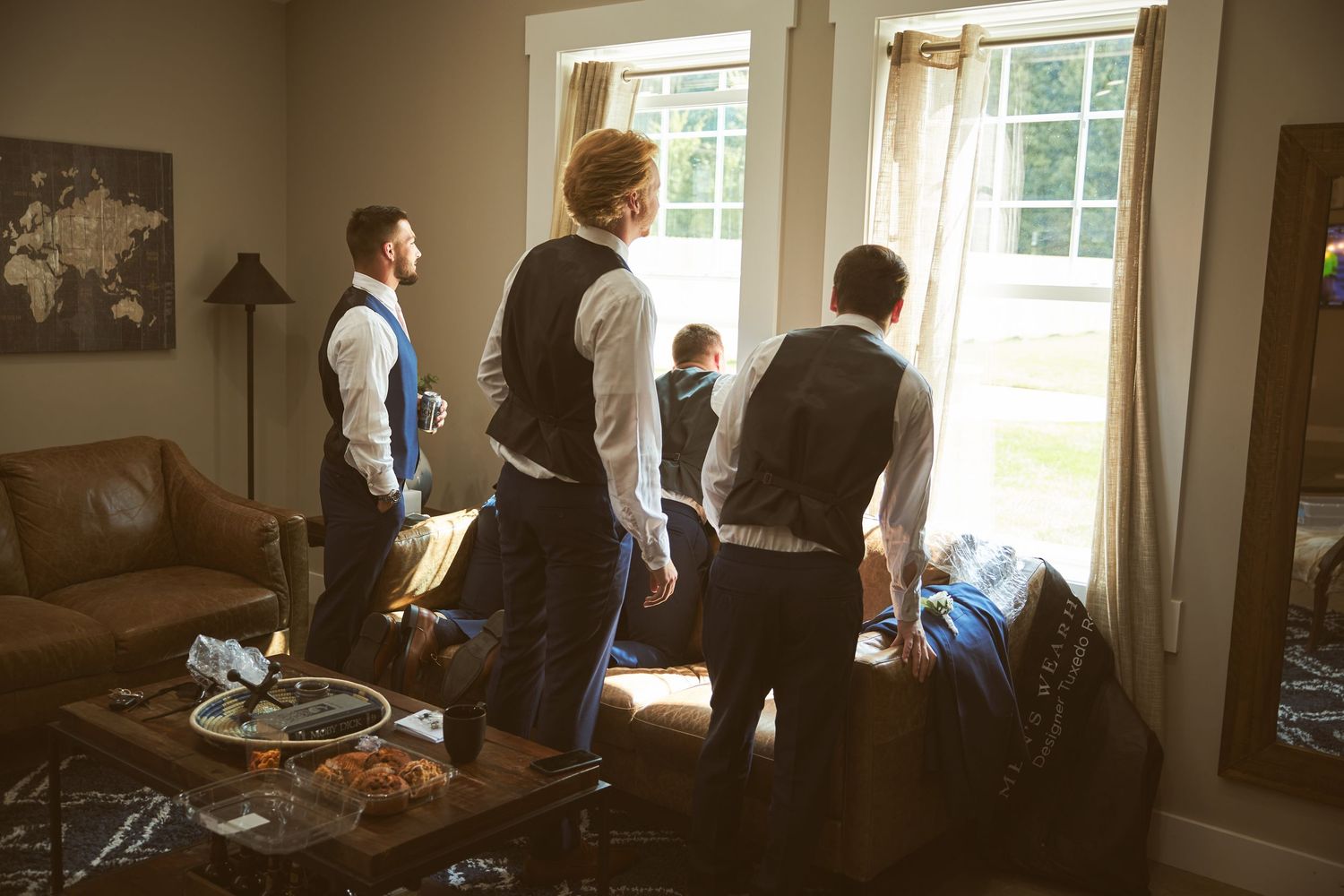 Interior scene of event preparations with people gathered near sunlit windows.