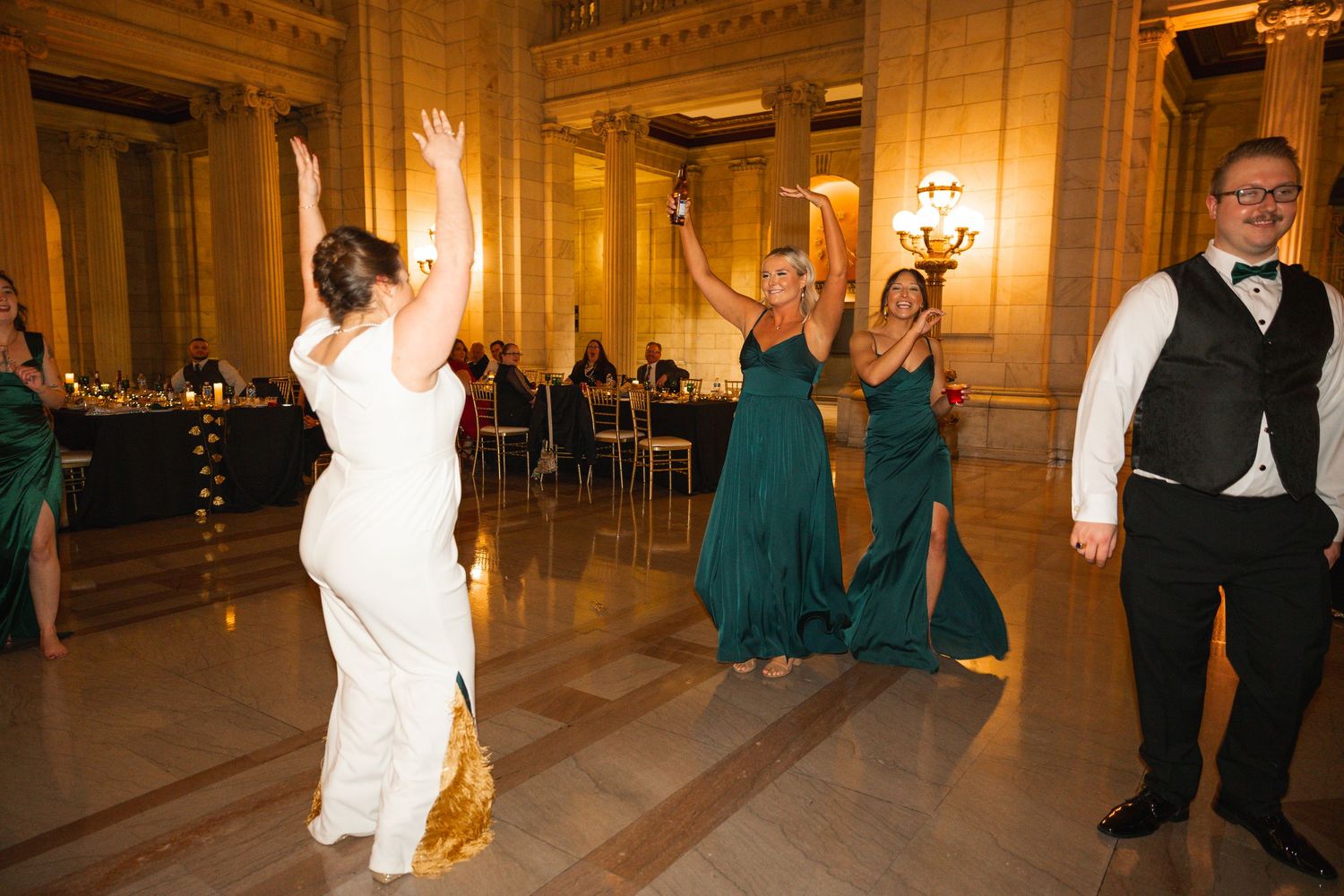 Elegant ballroom with ornate architectural details and warm lighting during wedding festivities.