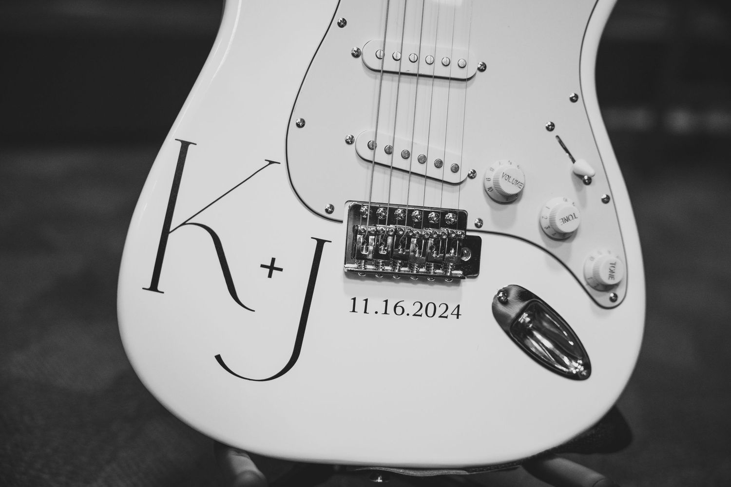 Close-up detail of a white electric guitar body showing pickup and control knob.