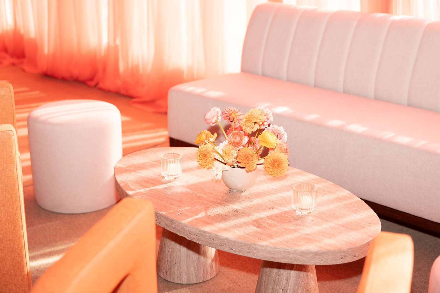 Modern restaurant interior with white tables and chairs illuminated by warm pink lighting creating an inviting ambiance.