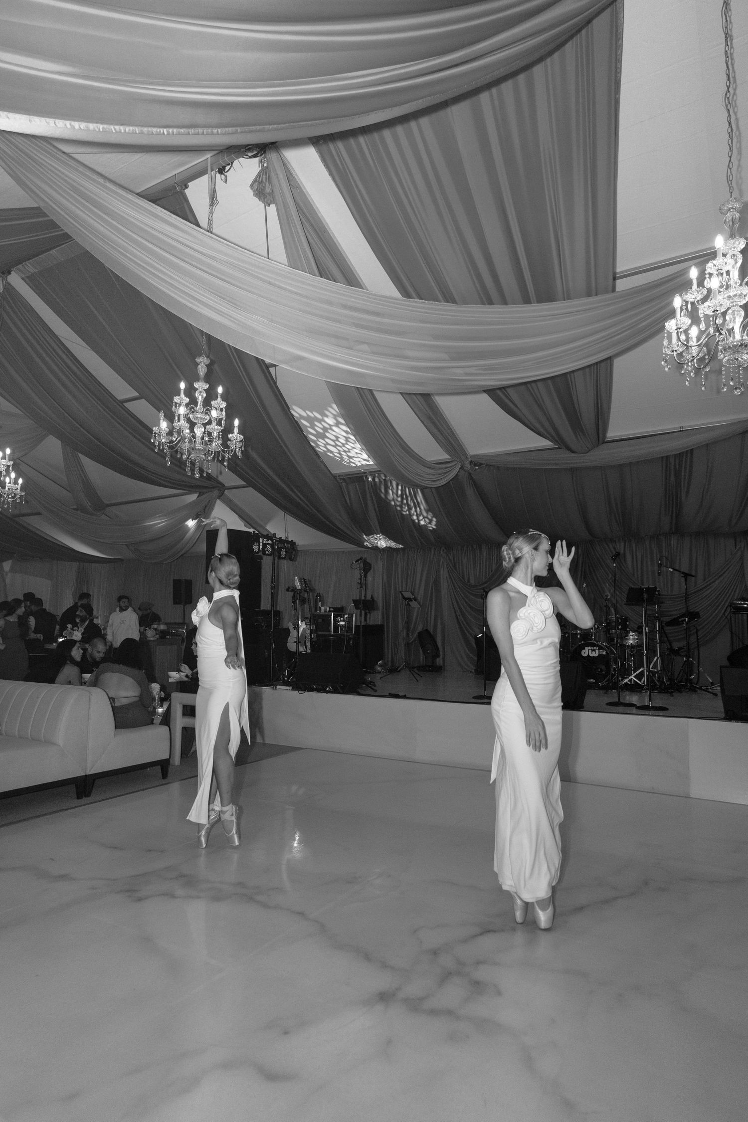 Black and white photos show couples dancing at an elegant wedding reception with draped fabric decor and chandeliers.
