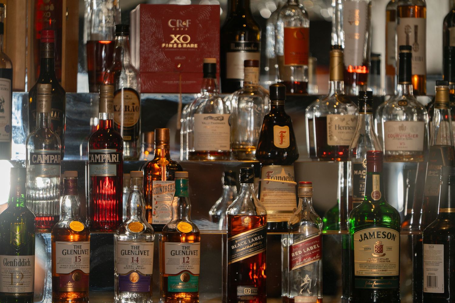Assorted liquor bottles displayed on shelves behind a bar.