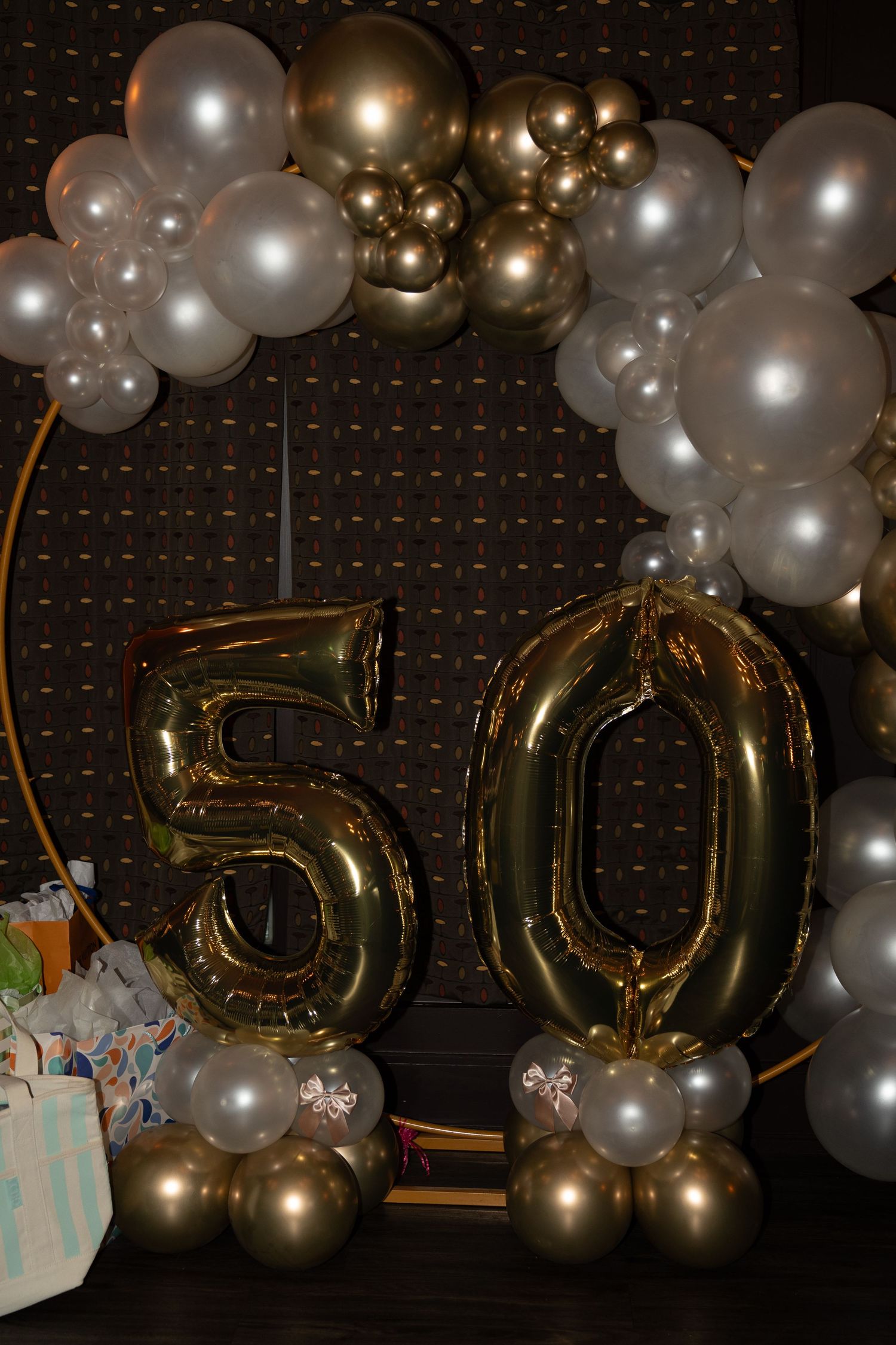 Gold and silver balloon arch with large number 50 decorations for anniversary celebration.