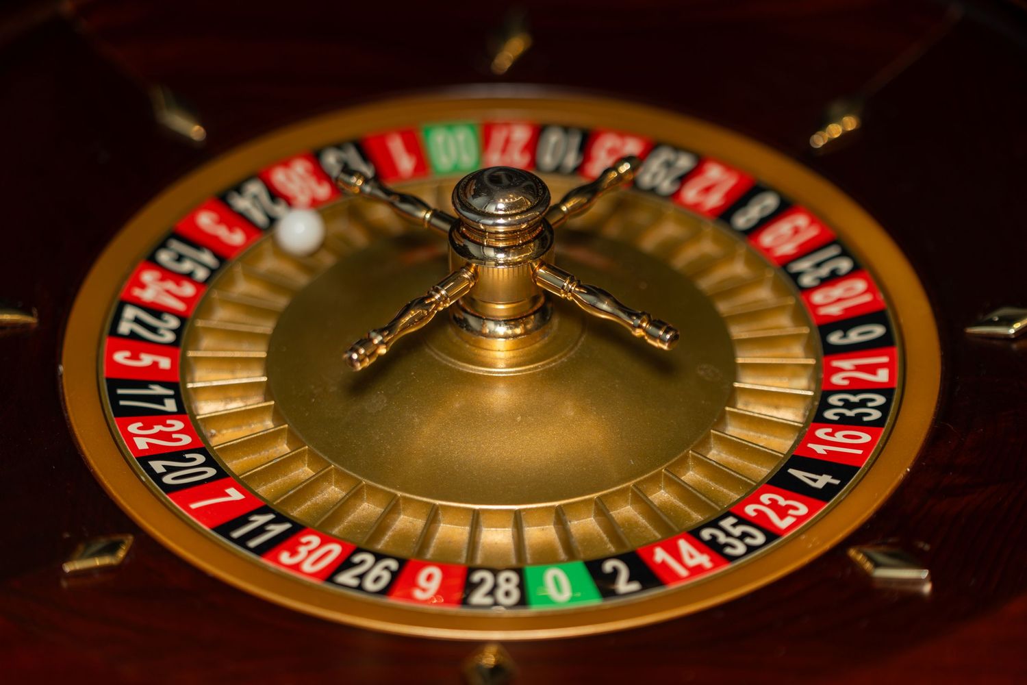 Close-up view of a spinning casino roulette wheel showing red, black and green numbered slots.