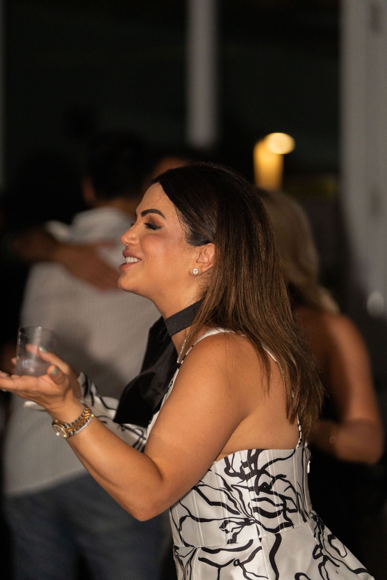 A person wearing a black and white dress poses and dances across multiple sequential party photos.