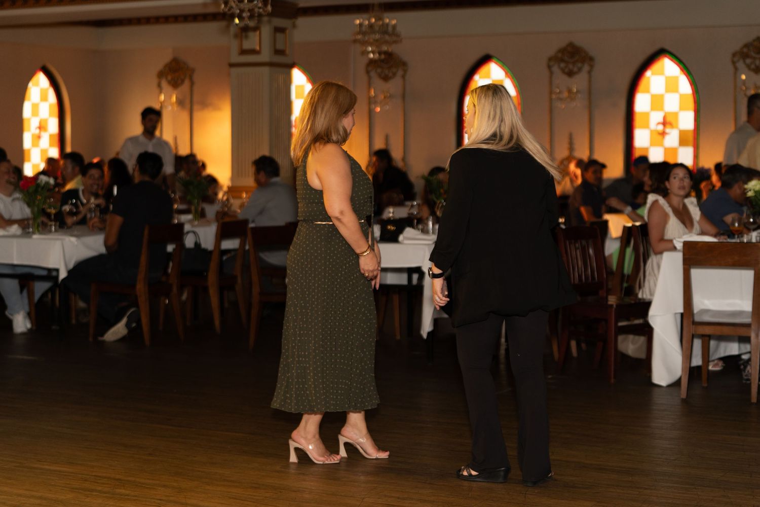 Elegant event space with arched windows and ambient lighting during an evening gathering.