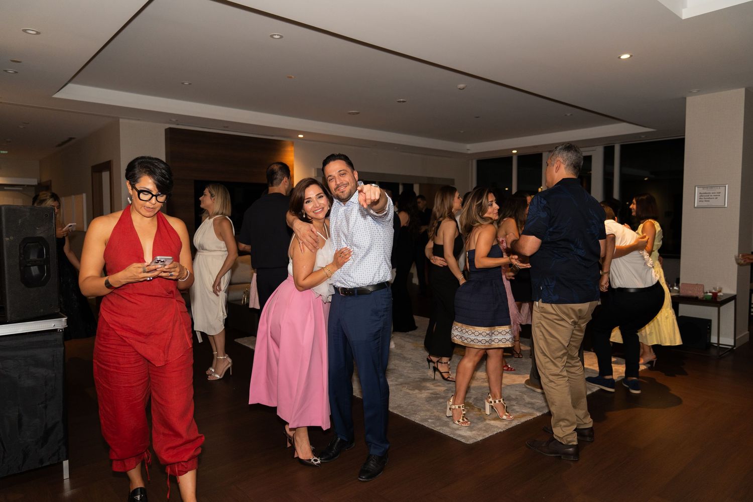 People dancing and enjoying themselves at a social gathering or party in an indoor venue.