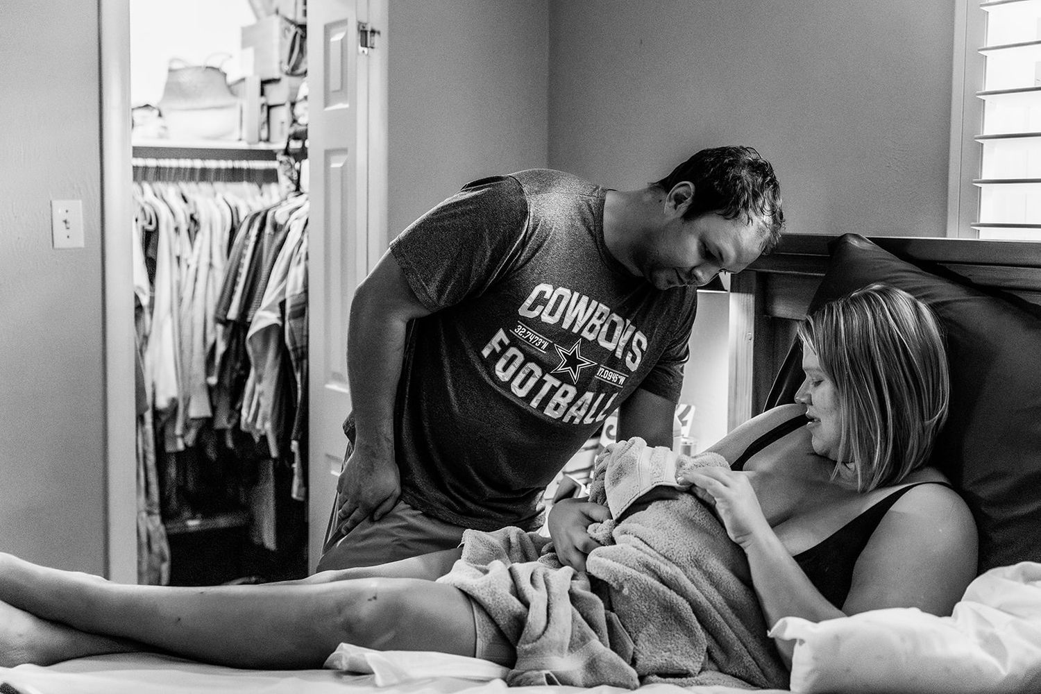mom and dad admiring newborn after a home birth in Odessa