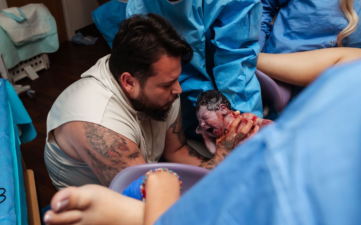 dad catching his baby during a hospital birth