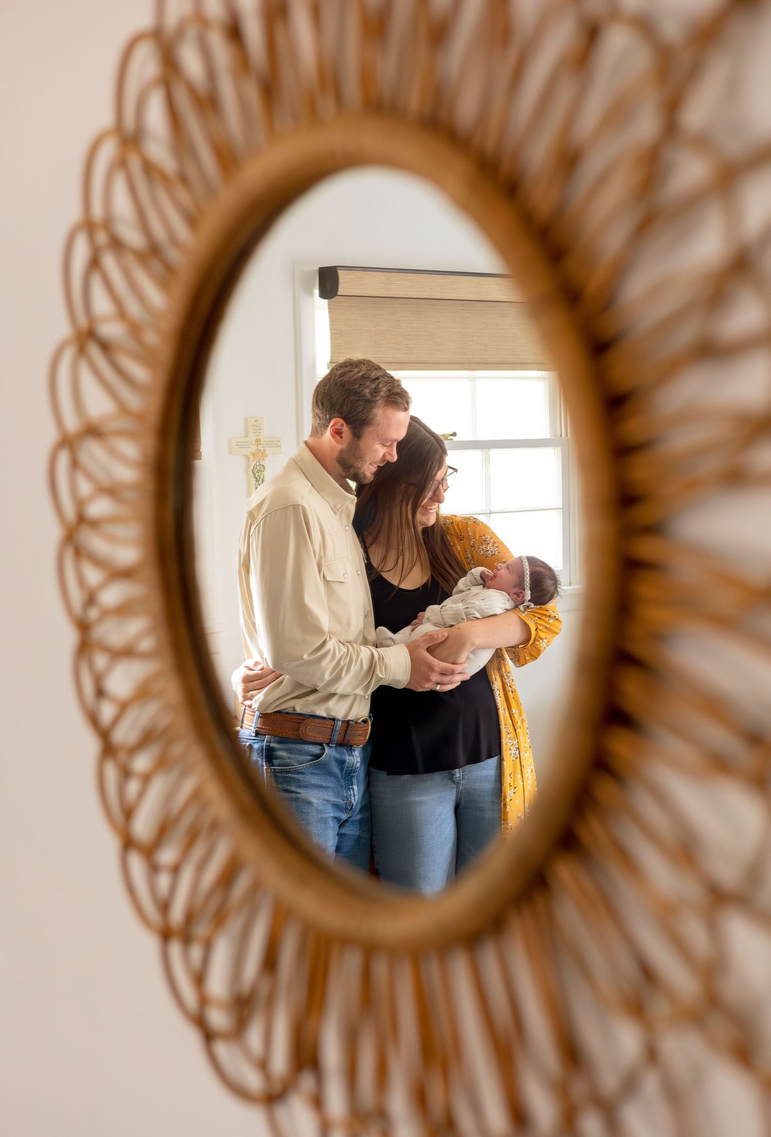 mirror shot of new parents holding newborn in the nursery during fresh 48 session
