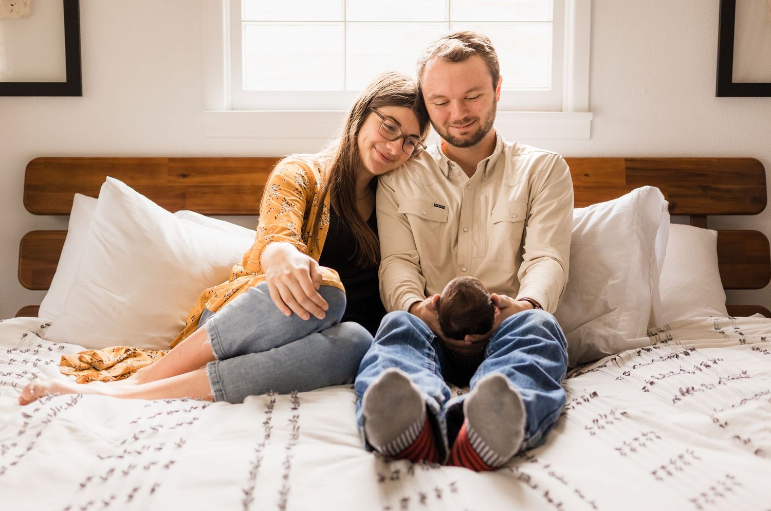 family of 3: newborn, mom and dad cuddling in bed during fresh 48 session