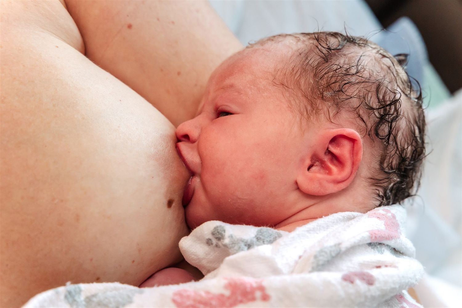 A newborn baby breastfeeding while lying on mothers chest at Midland Memorial Hospital