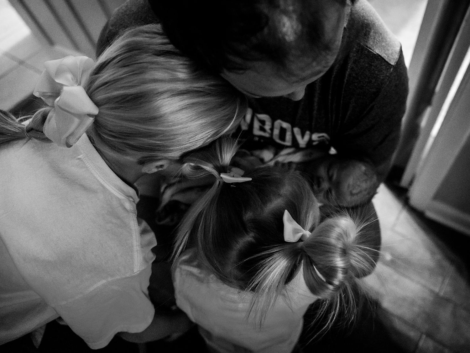 dad cradling his newborn baby with 2 daughters in photo for fresh 48 session