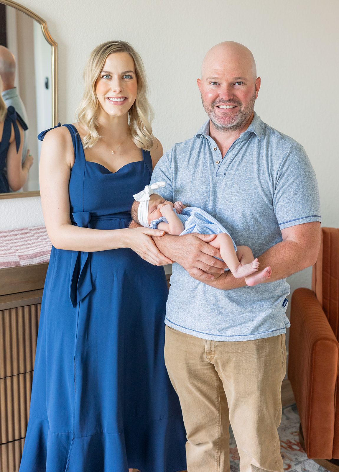 A couple in blue poses together while holding a newborn baby in a series of photos. fresh 48