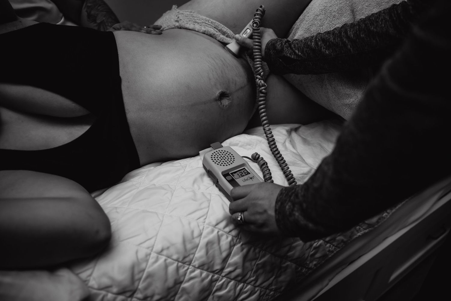 mom in labor at birth center having babies heart tones checked with fetal doppler