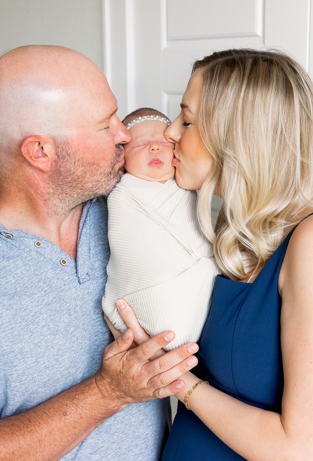 mom and dad kissing newborn baby face at fresh 48 session in midland Texas