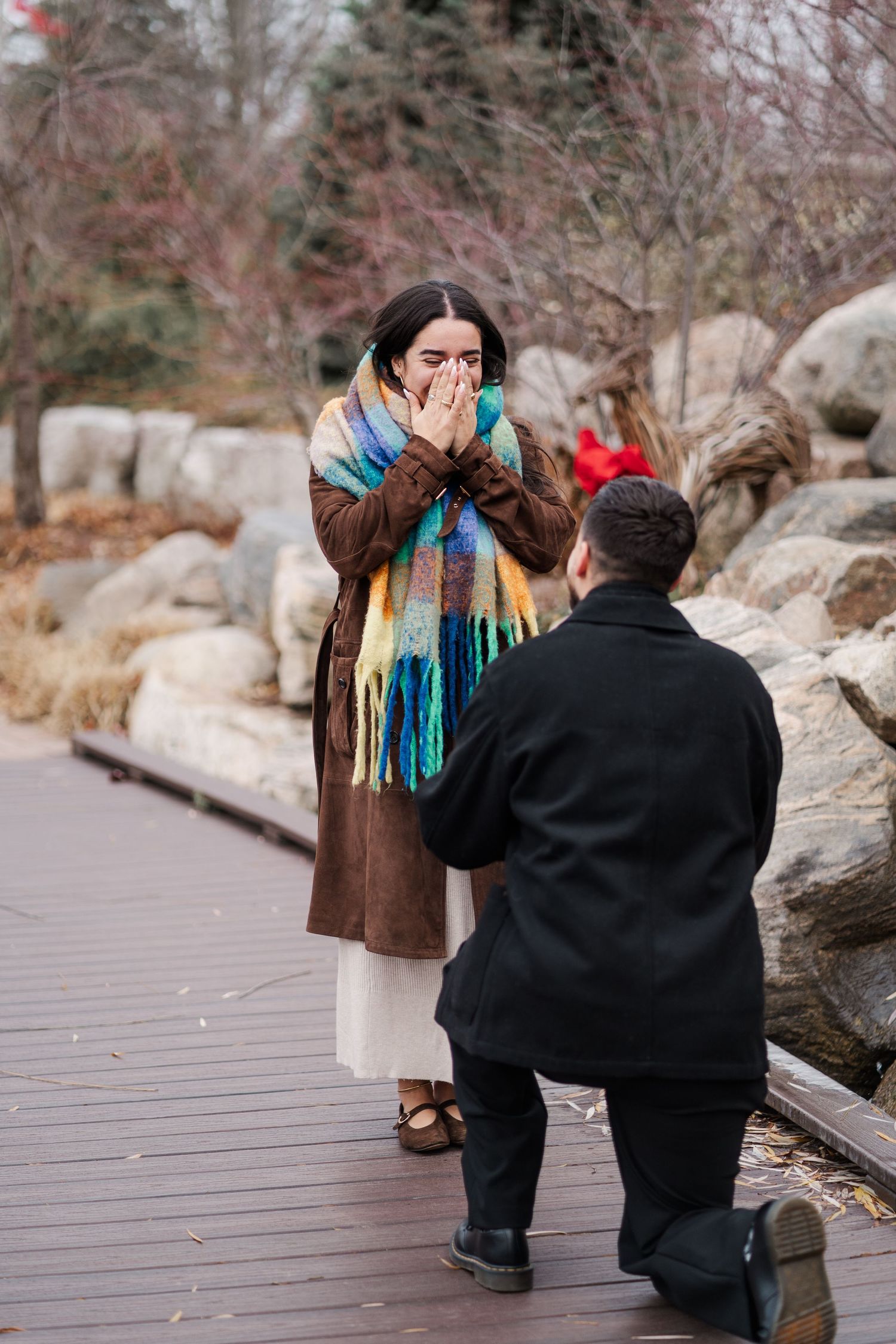 An emotional marriage proposal captured on a wooden walkway with rocks and winter foliage.
Niagara engagement photos and proposal photos.