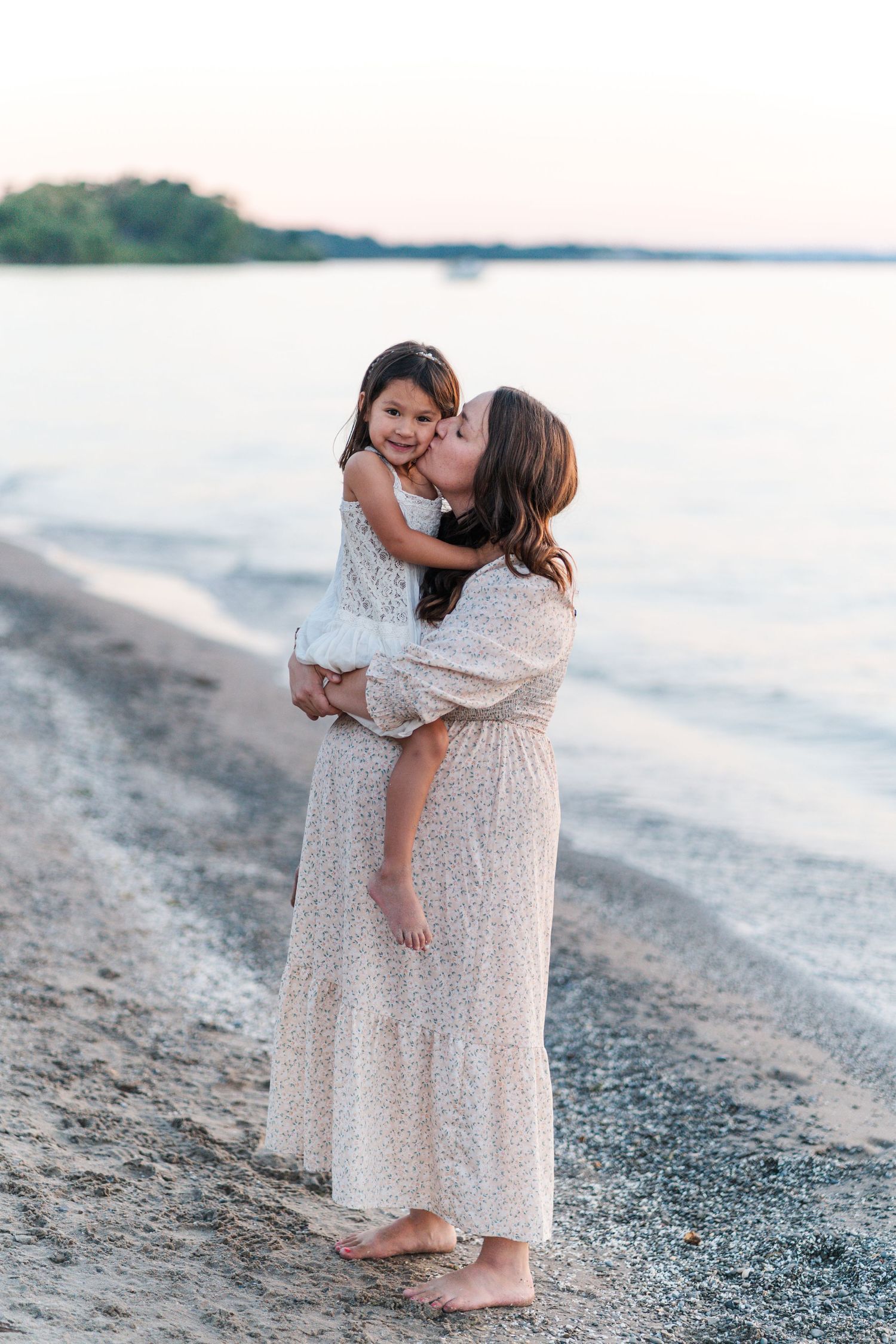 Mother and child share tender embraces during beach portrait session at sunset.
Niagara family photos.