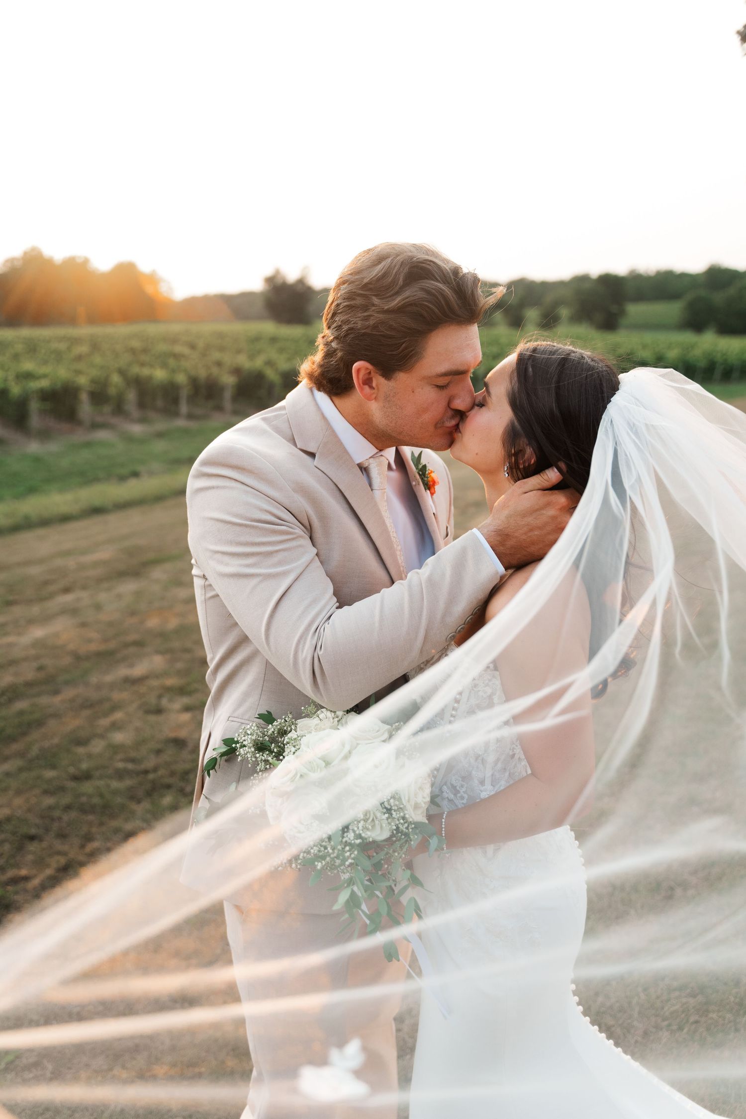 Wedding couple shares intimate moment as veil flows dramatically in golden sunlight.
Niagara wedding photos.
