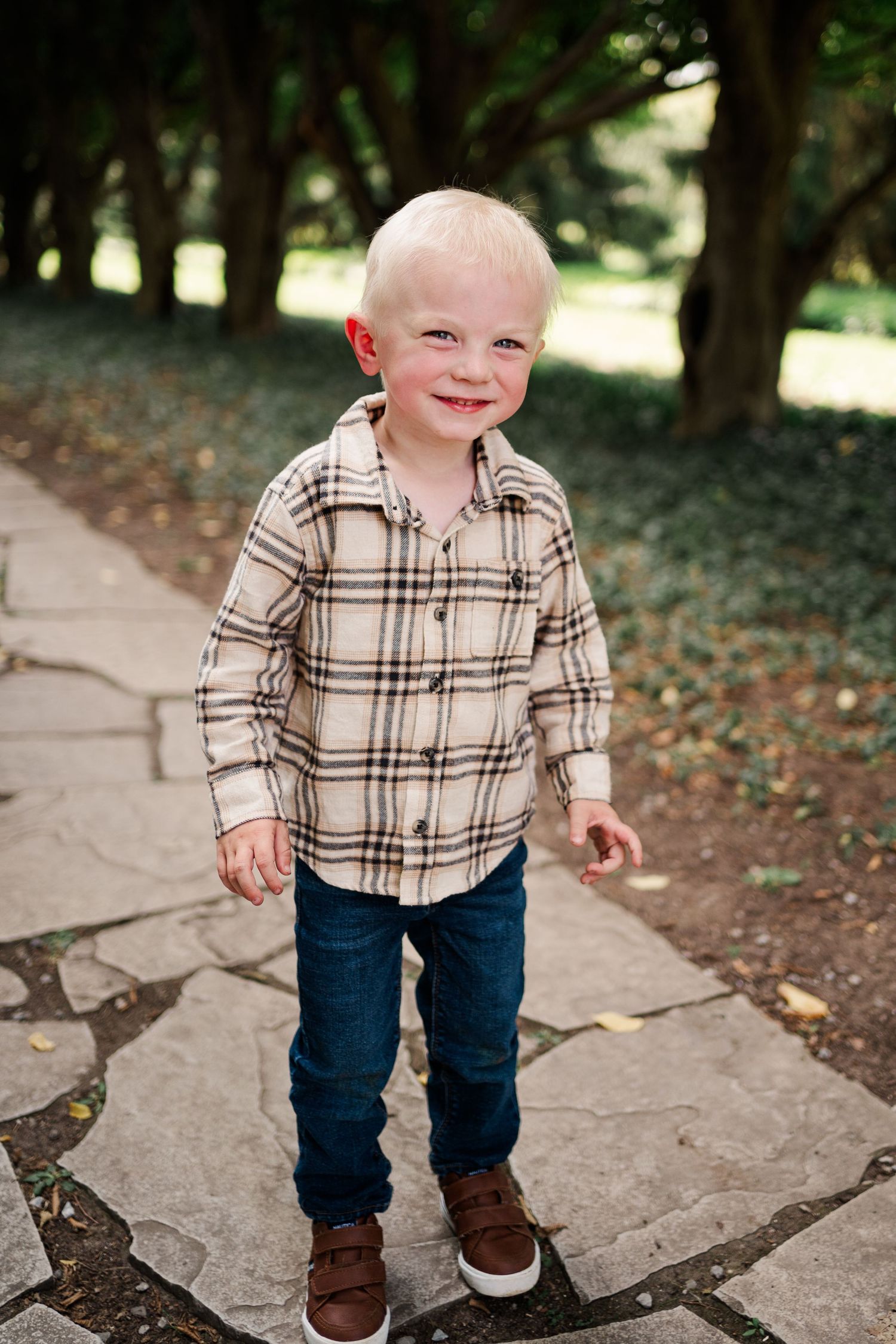 Small child in plaid shirt and jeans walks along stone pathway.
Family photos in Niagara