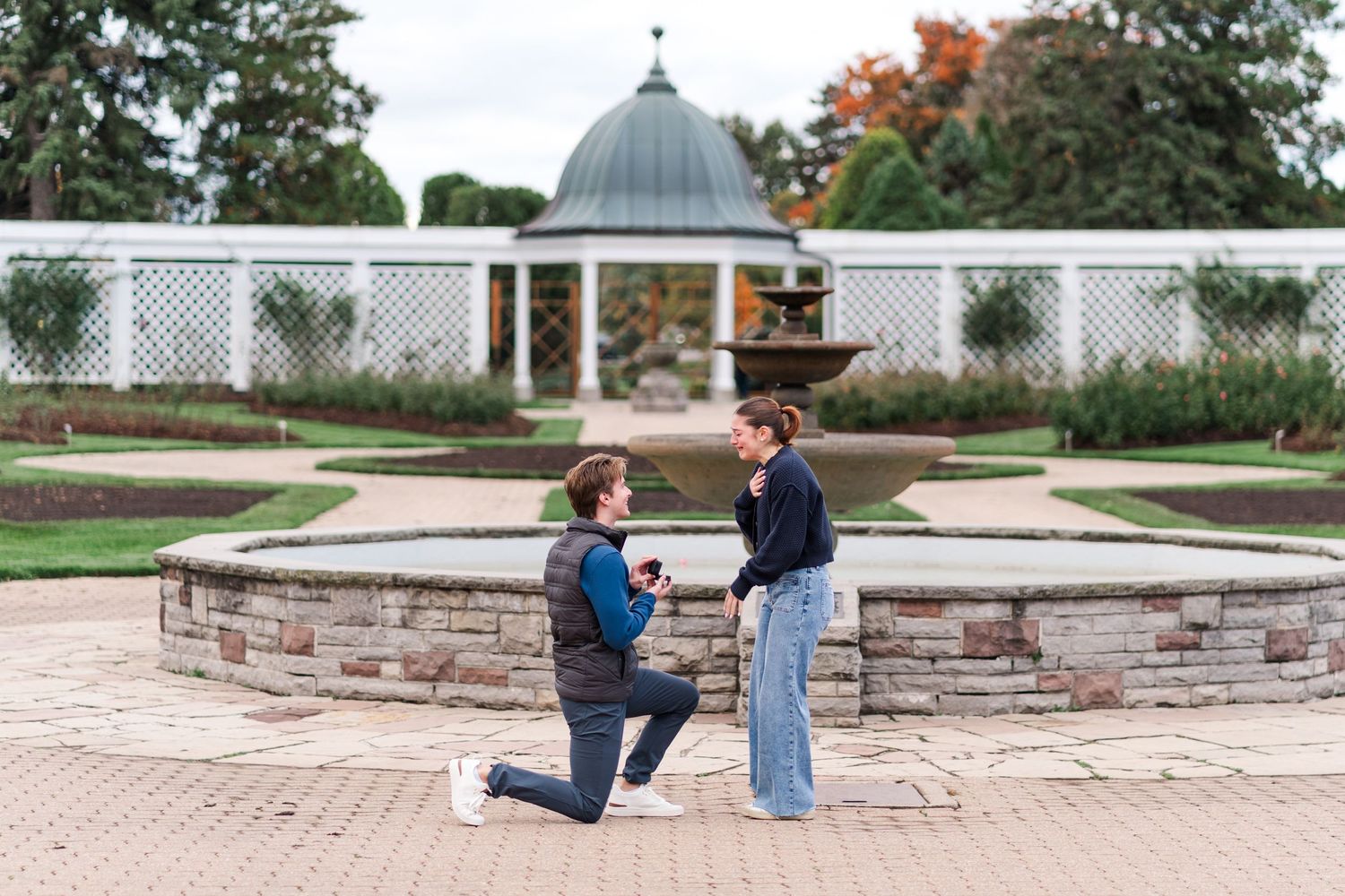 A proposal scene in front of an elegant domed gazebo with white lattice fencing.
Niagara proposal photos.