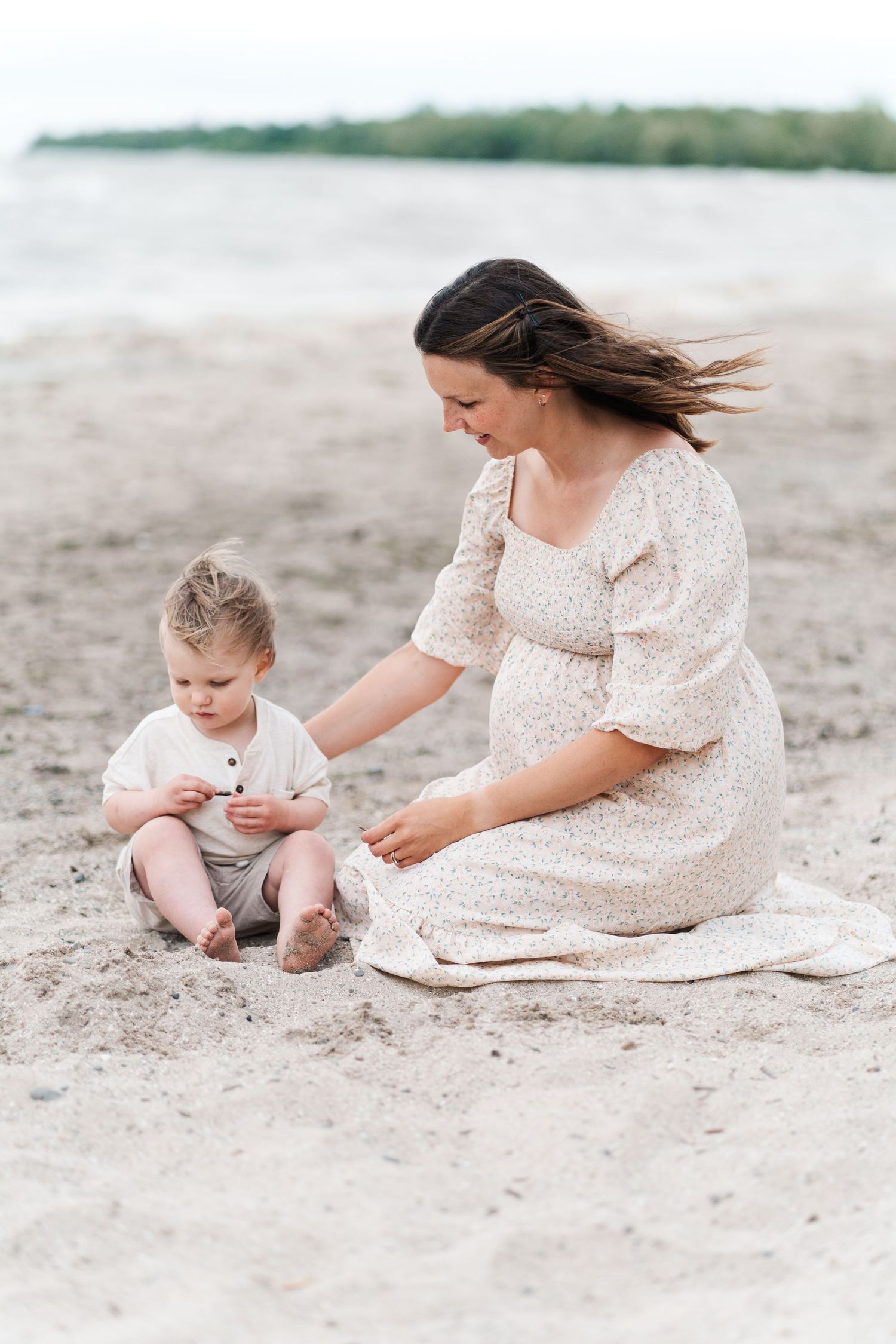 A serene beach scene with a pregnant woman and child playing in the sand.
Niagara family photos.