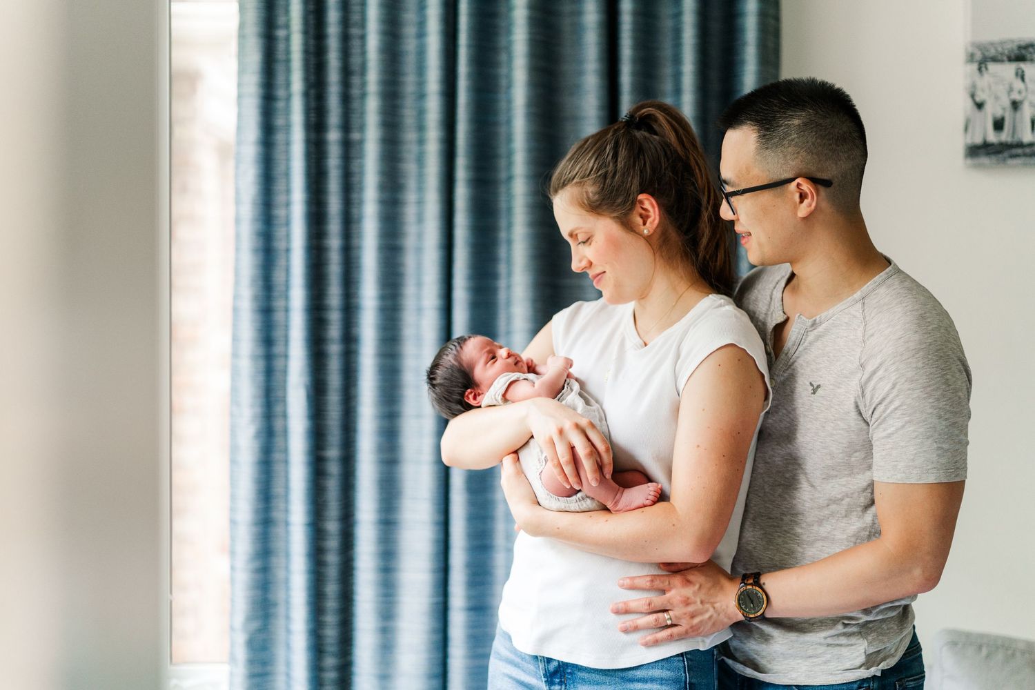 Family members holding and bonding with newborn in cozy home setting.
Niagara newborn photos.