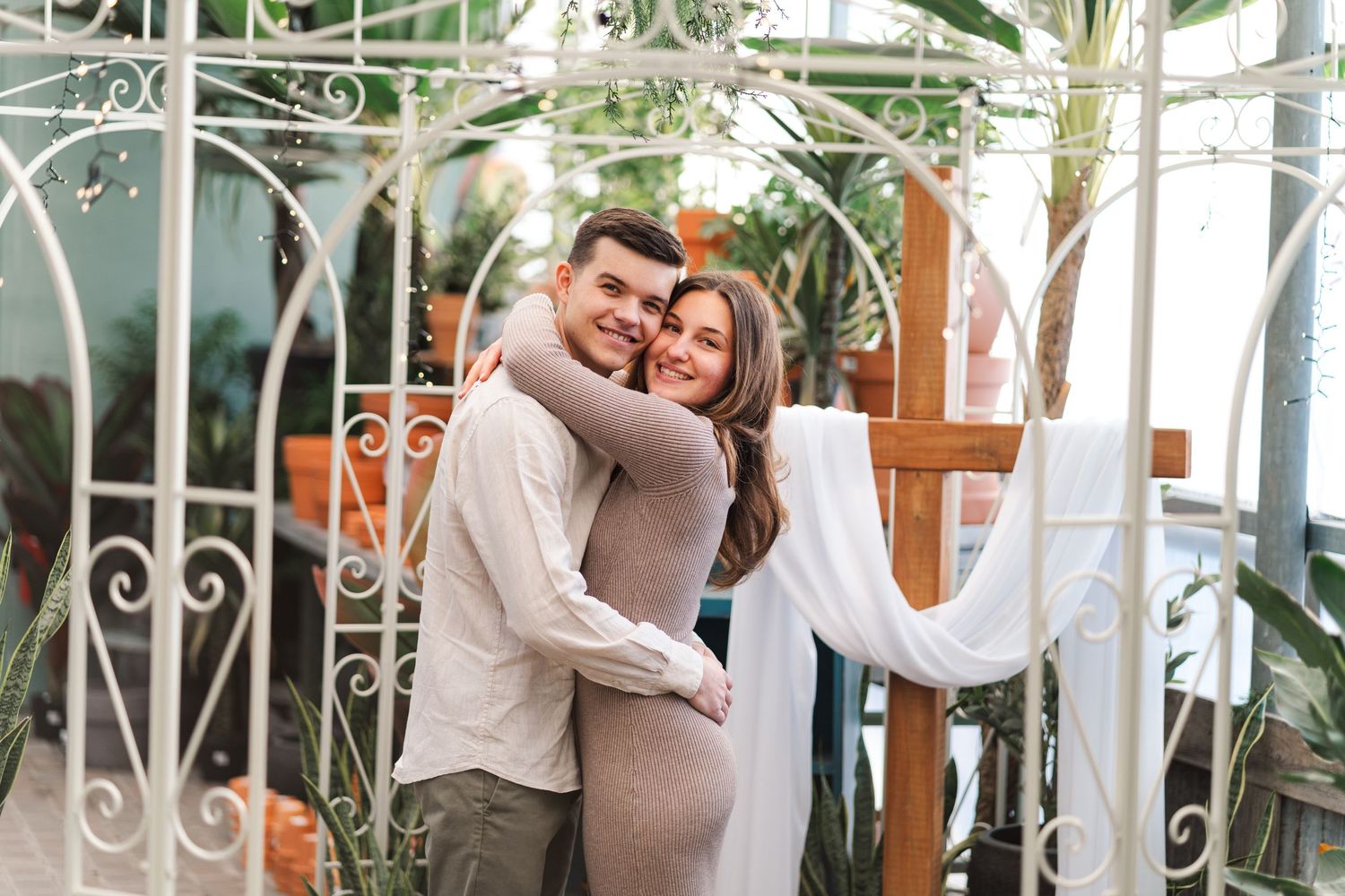 A couple shares a romantic dance moment in an elegant conservatory setting with lush greenery and white decor.
Niagara proposals.