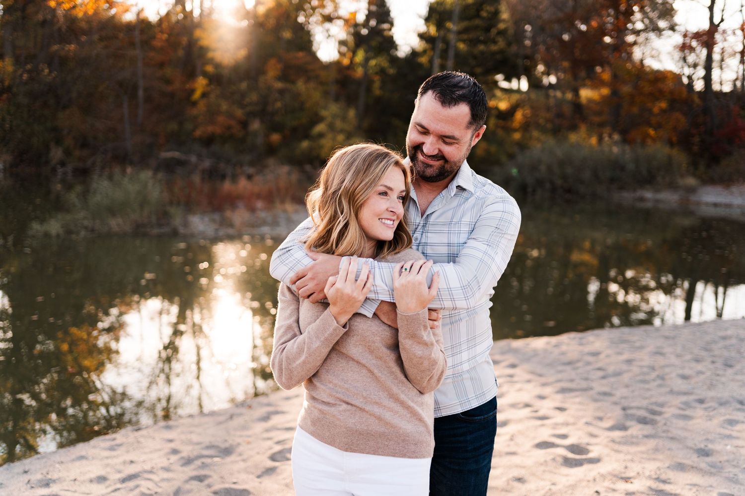 Romantic sunset photoshoot on a sandy beach with water reflections in the background.Niagara engagement photos.