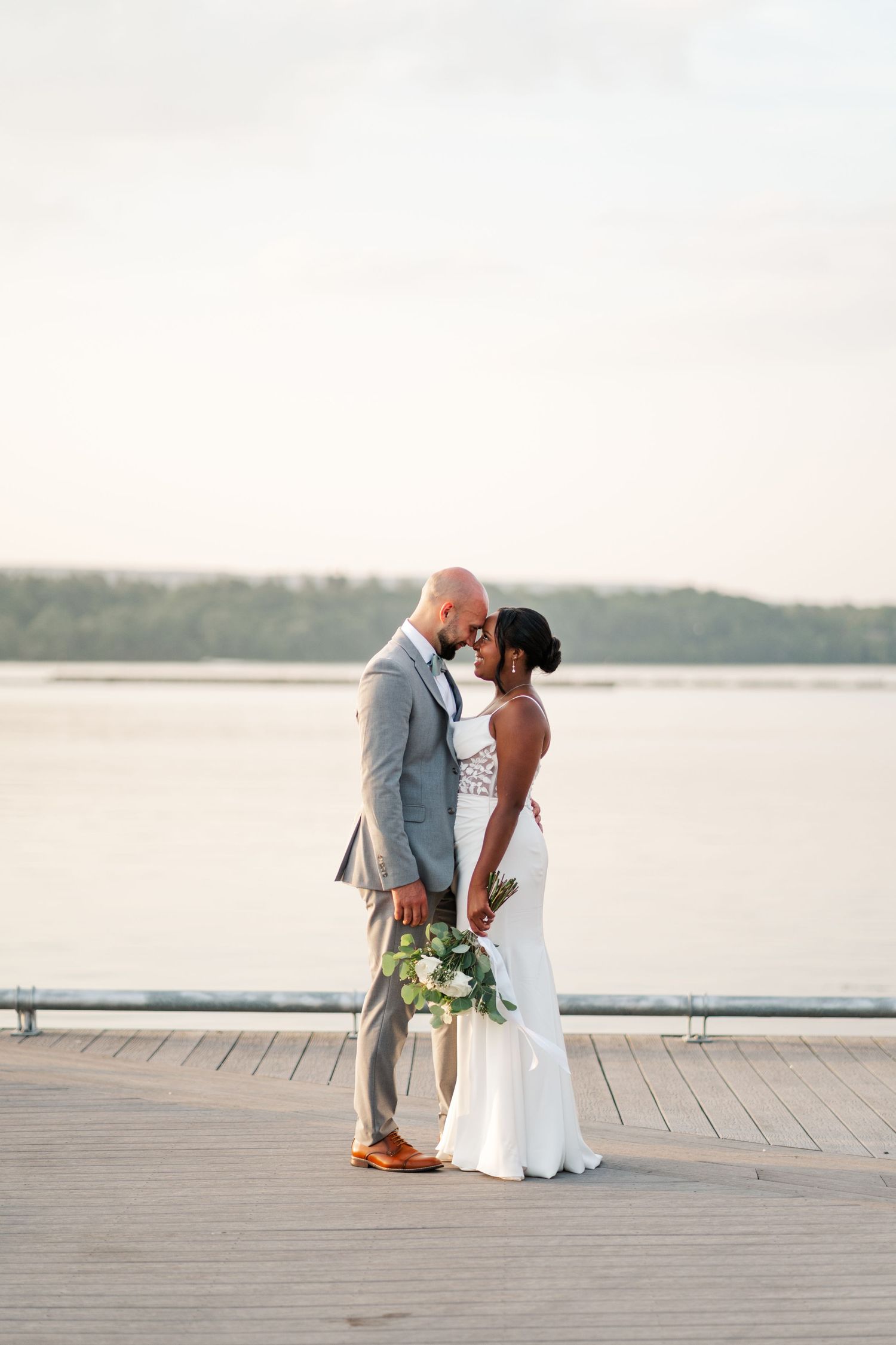 Romantic moment captured on wooden dock overlooking serene lake at sunset.
Niagara wedding photos.