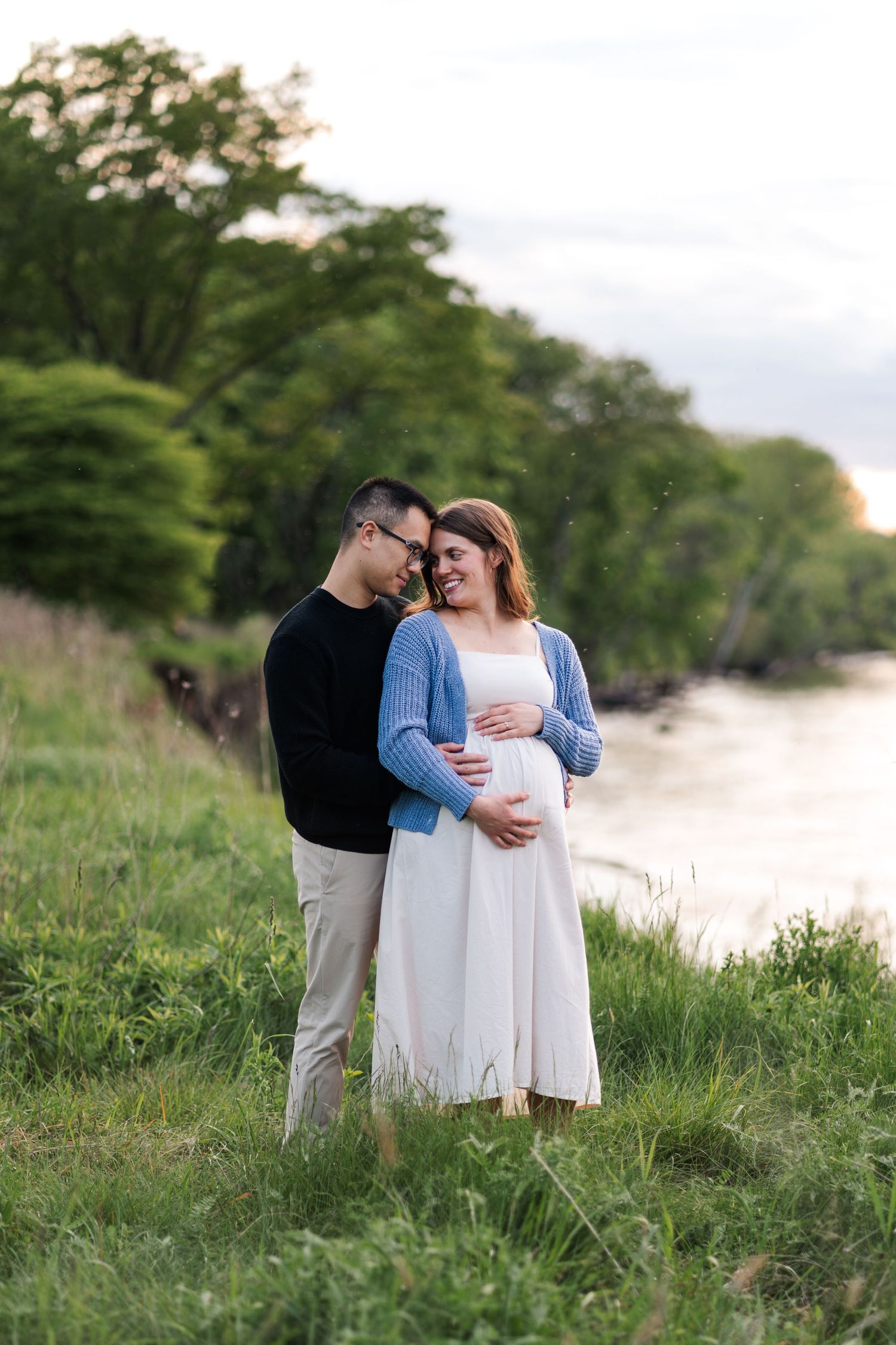 Couple shares tender moments during sunset photoshoot by a serene waterfront.
Niagara maternity photos.