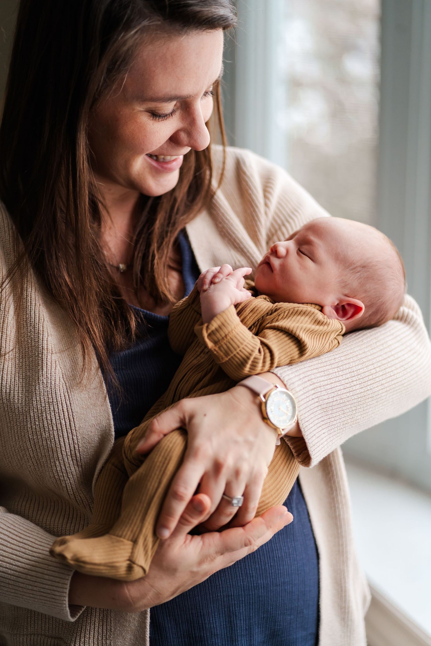 Tender moments captured between parent and newborn by a bright window.
Niagara newborn photos.