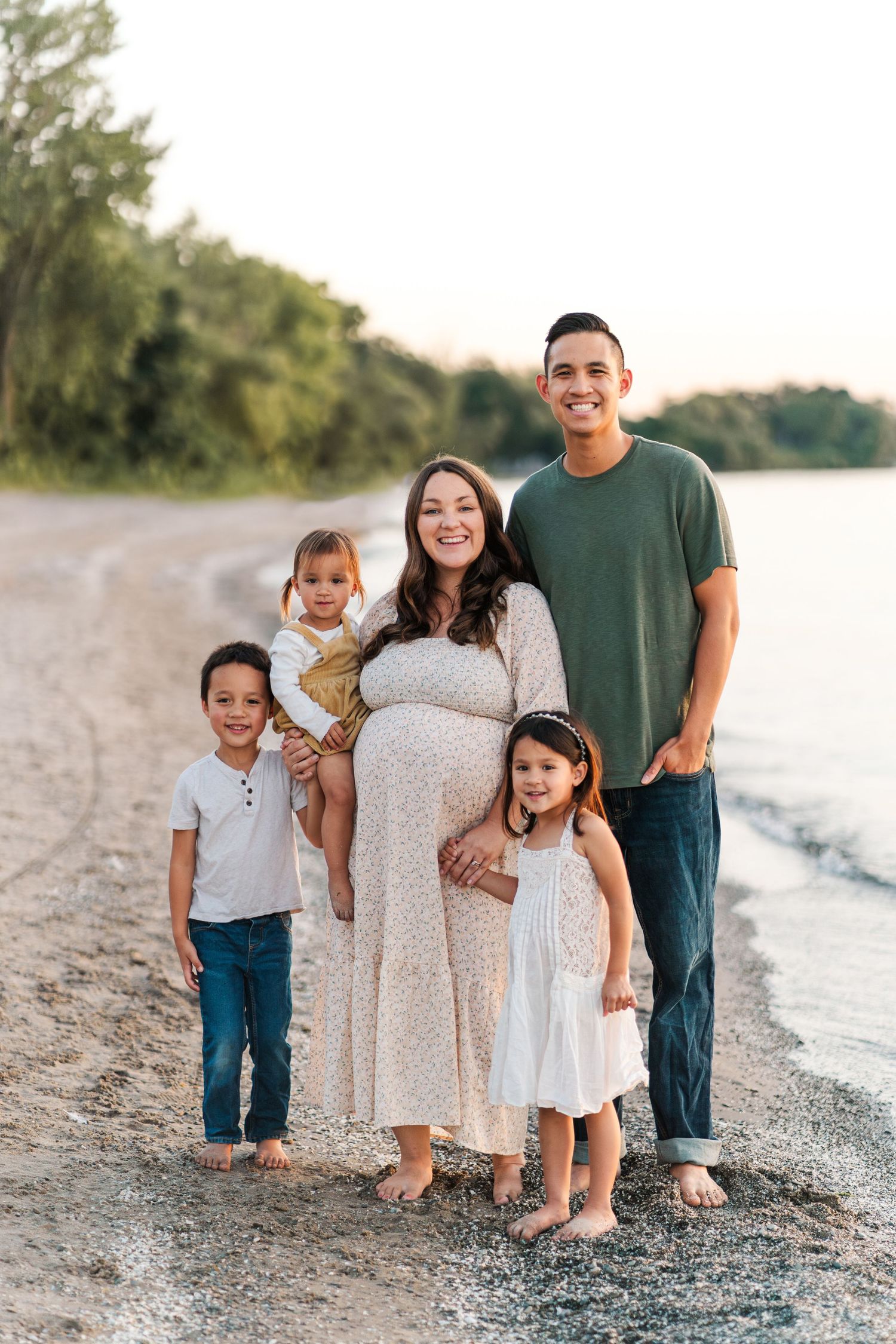 Family of five poses together on beach at sunset.
Niagara family photos.